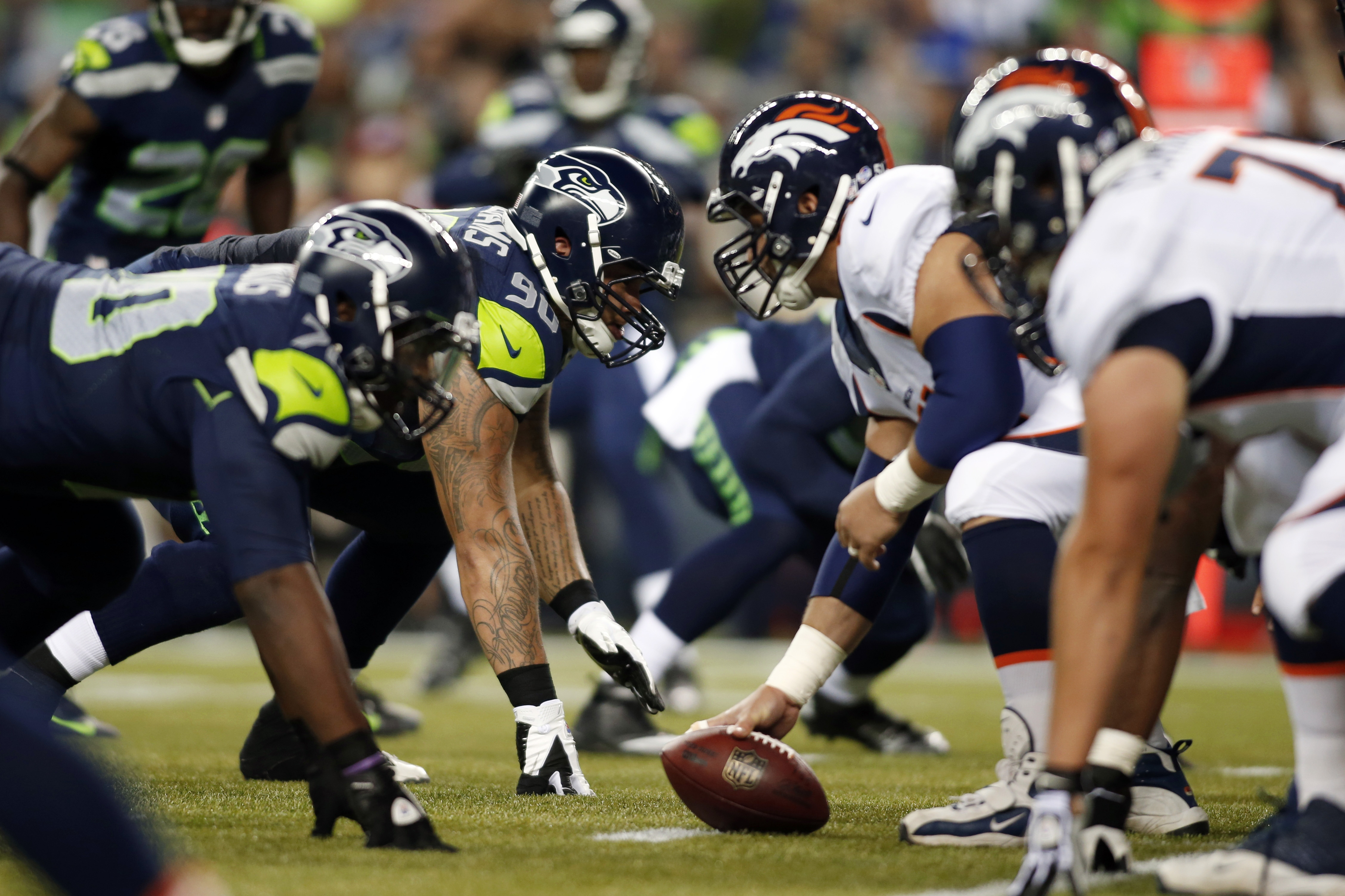 ADVANCE FOR WEEKEND EDITIONS, JAN. 25-26 - FILE - In this Aug. 17, 2013, file photo, Seattle Seahawks' Jesse Williams (90) lines up with teammates at the line of scrimmage against the Denver Broncos in the second half of a preseason NFL football game,  in Seattle. The two teams are slated to meet in Super Bowl XLVIII on Sunday, Feb. 2, 2014, in East Rutherford, N.J. (AP Photo/John Froschauer, File)