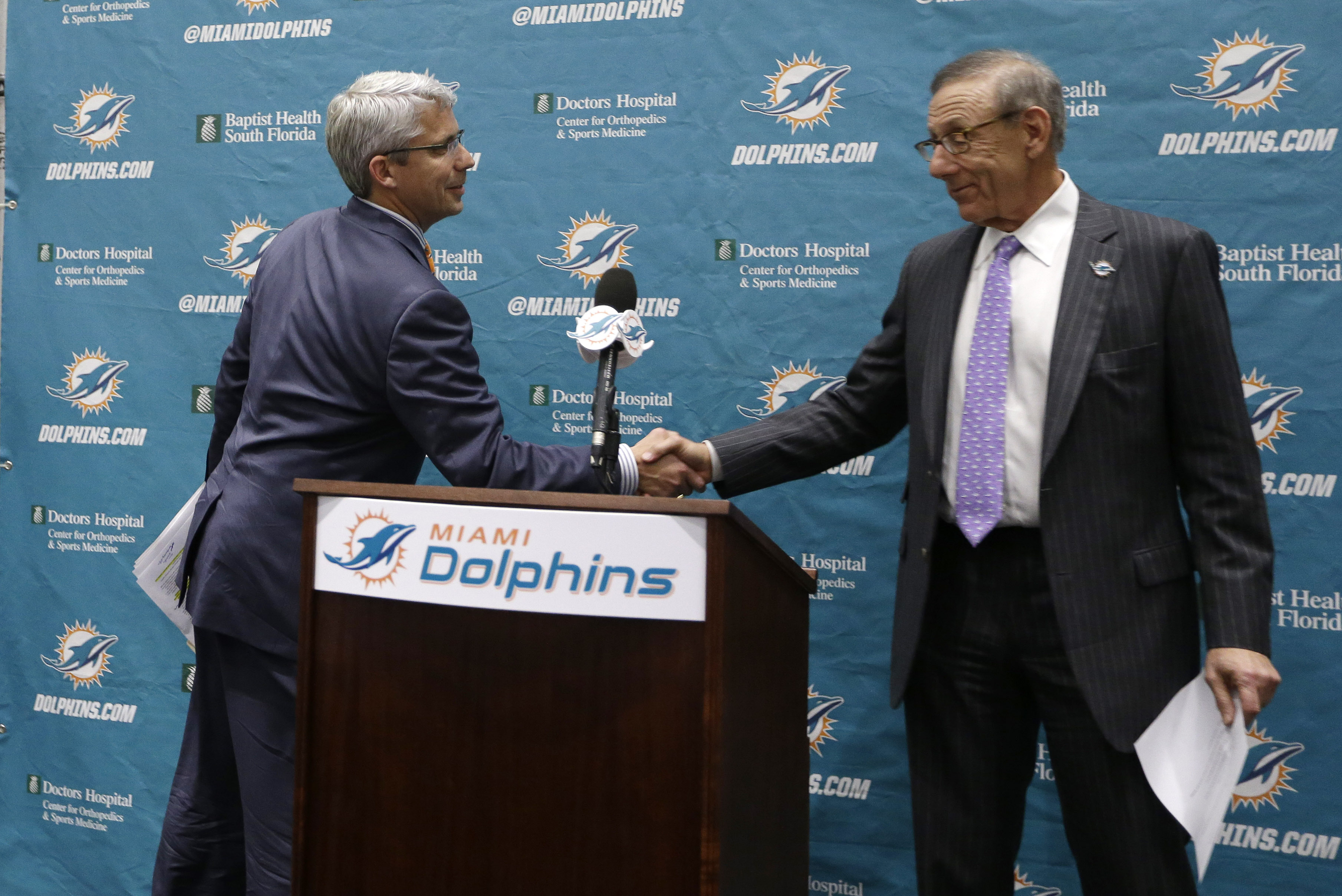 Dennis Hickey, new general manager for the Miami Dolphins football team, left,  shakes hands with team owner Stephen Ross, right, during a news conference, Tuesday, Jan. 28, 2014, in Davie, Fla. (AP Photo/Lynne Sladky)