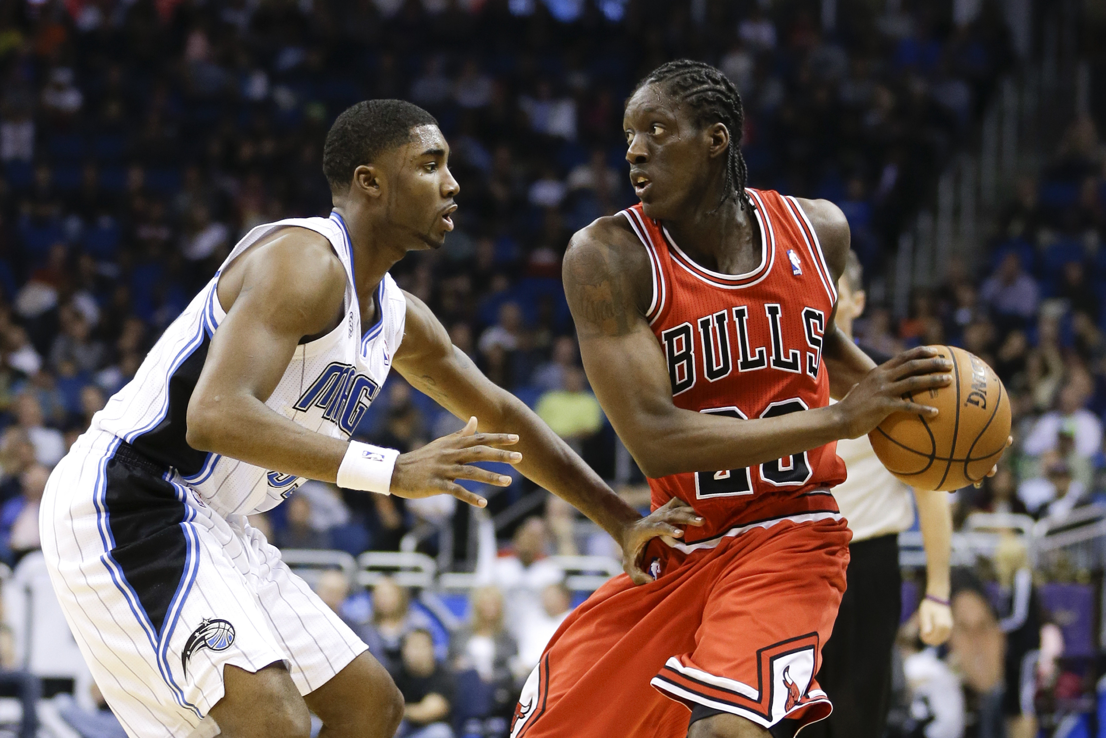 Chicago Bulls' Tony Snell, right, looks to pass the ball around Orlando Magic's E'Twaun Moore, left, during the first half of an NBA basketball game in Orlando, Fla., Wednesday, Jan. 15, 2014.(AP Photo/John Raoux)