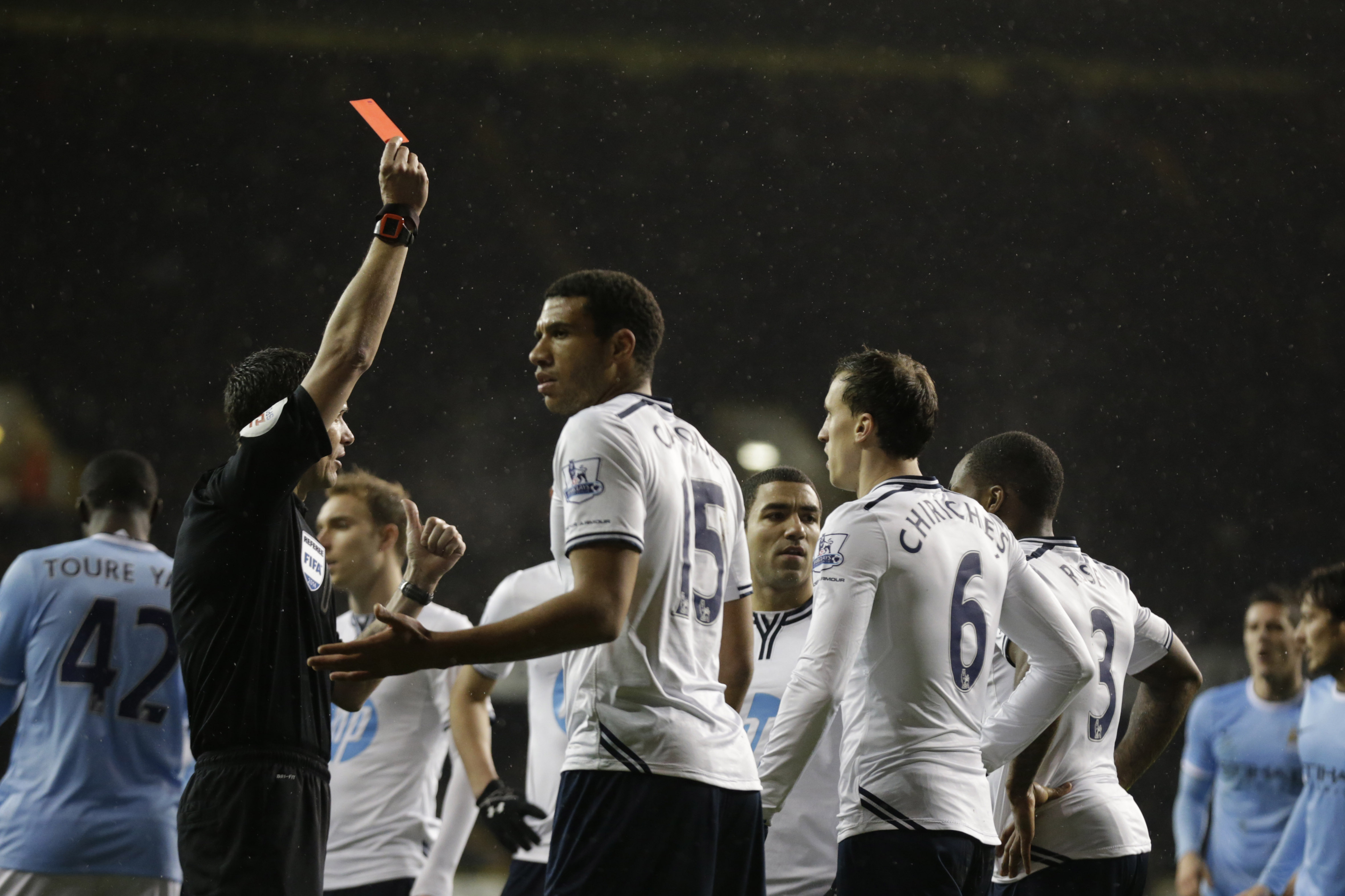 Referee Andre Marriner shows a red card to Tottenham Hotspur's Danny Rose, number 3 third right, for a penalty challenge on Manchester City's Edin Dzeko, not pictured, during the English Premier League soccer match between Tottenham Hotspur and Manchester City at White Hart Lane stadium in London, Wednesday, Jan. 29, 2014.  (AP Photo/Matt Dunham)