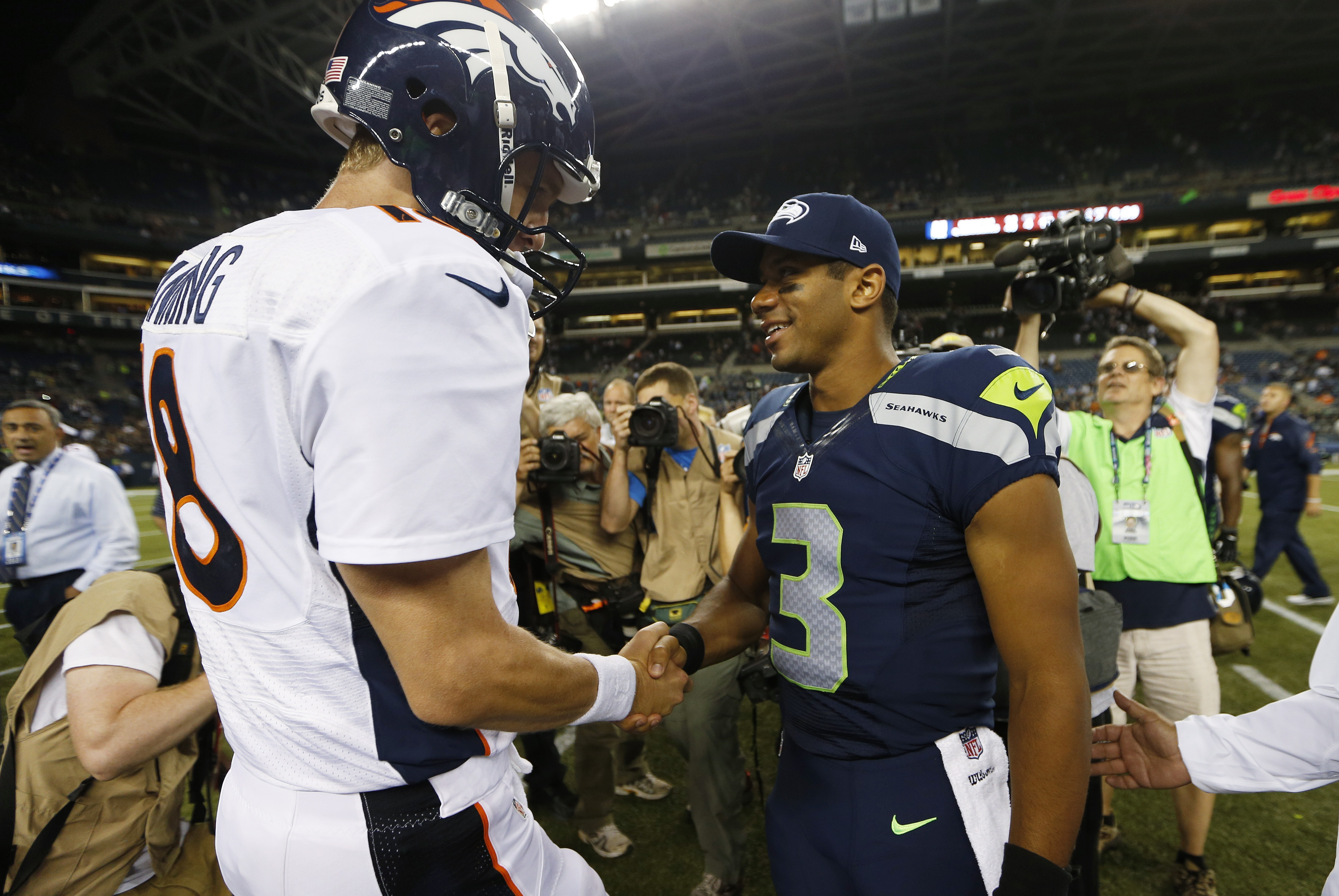 Seattle Seahawks quarterback Russell Wilson (3) shakes hands with Denver Broncos quarterback Peyton Manning, left, after the Seahawks beat the Broncos 40-10, in preseason NFL football game, Saturday, Aug. 17, 2013, in Seattle. (AP Photo/John Froschauer)