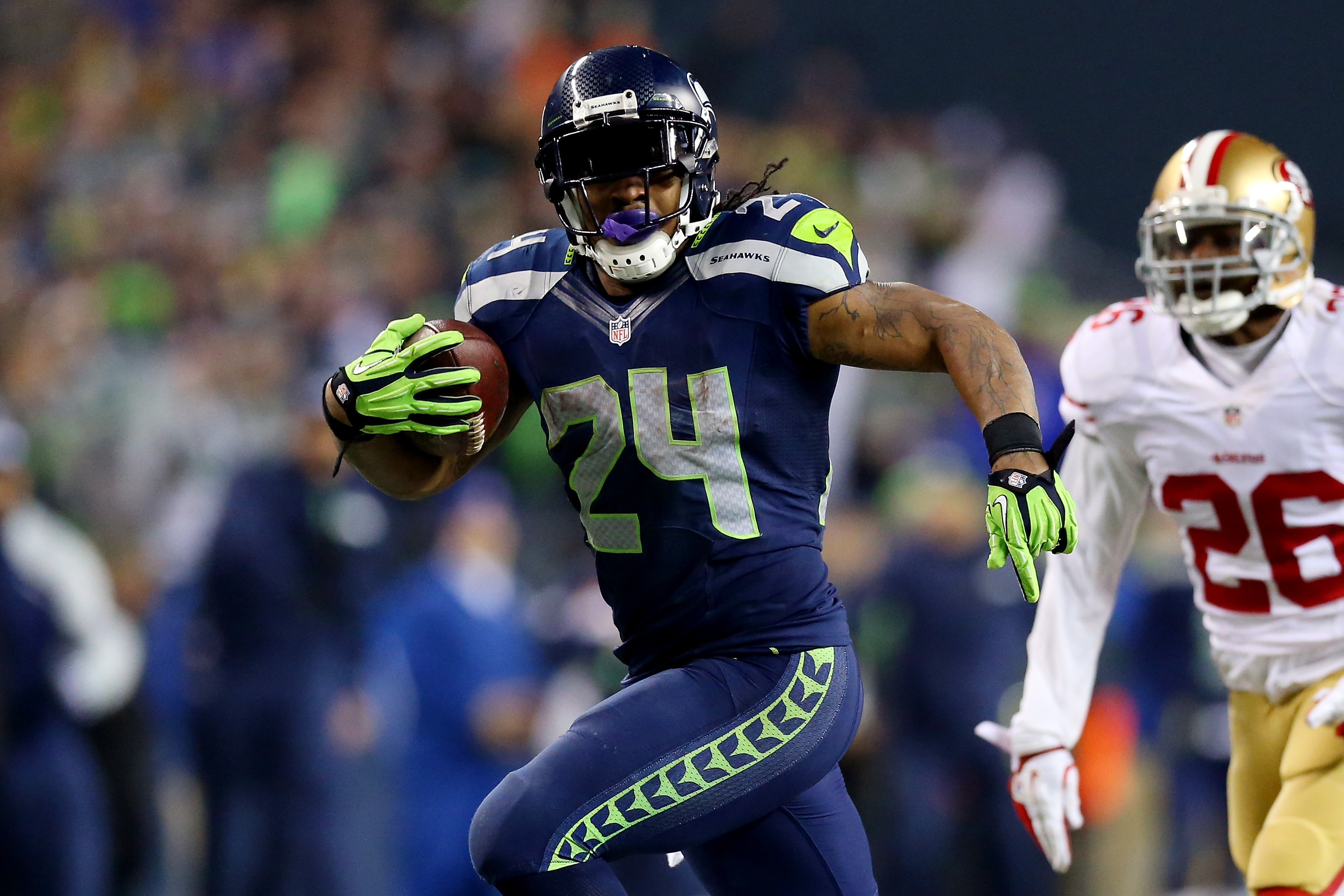 SEATTLE, WA - JANUARY 19:  Running back Marshawn Lynch #24 of the Seattle Seahawks scores a 40-yard touchdown against cornerback Tramaine Brock #26 of the San Francisco 49ers in the third quarter during the 2014 NFC Championship at CenturyLink Field on January 19, 2014 in Seattle, Washington.  (Photo by Ronald Martinez/Getty Images)