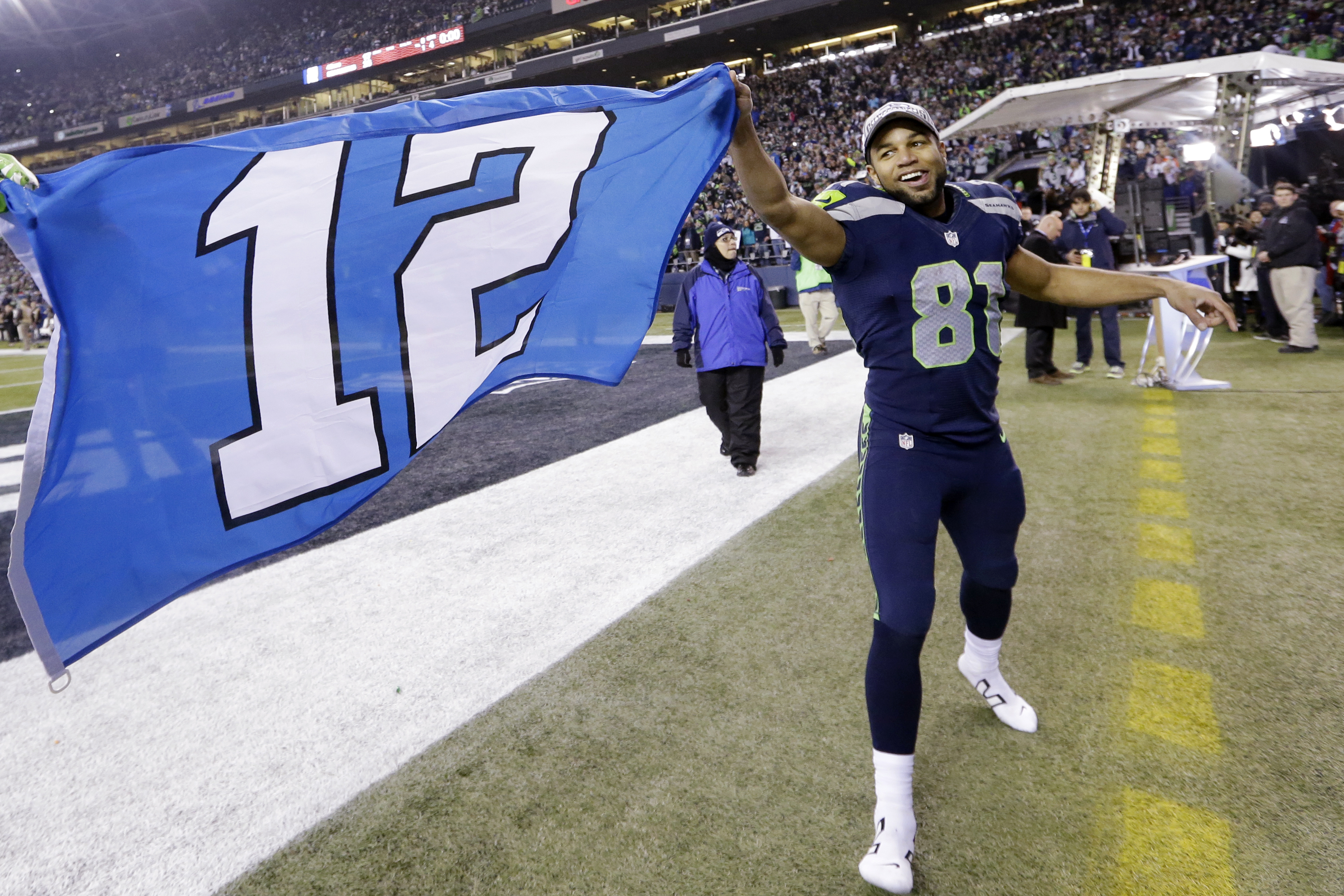 Seattle Seahawks' Golden Tate runs around the field holding one end of a