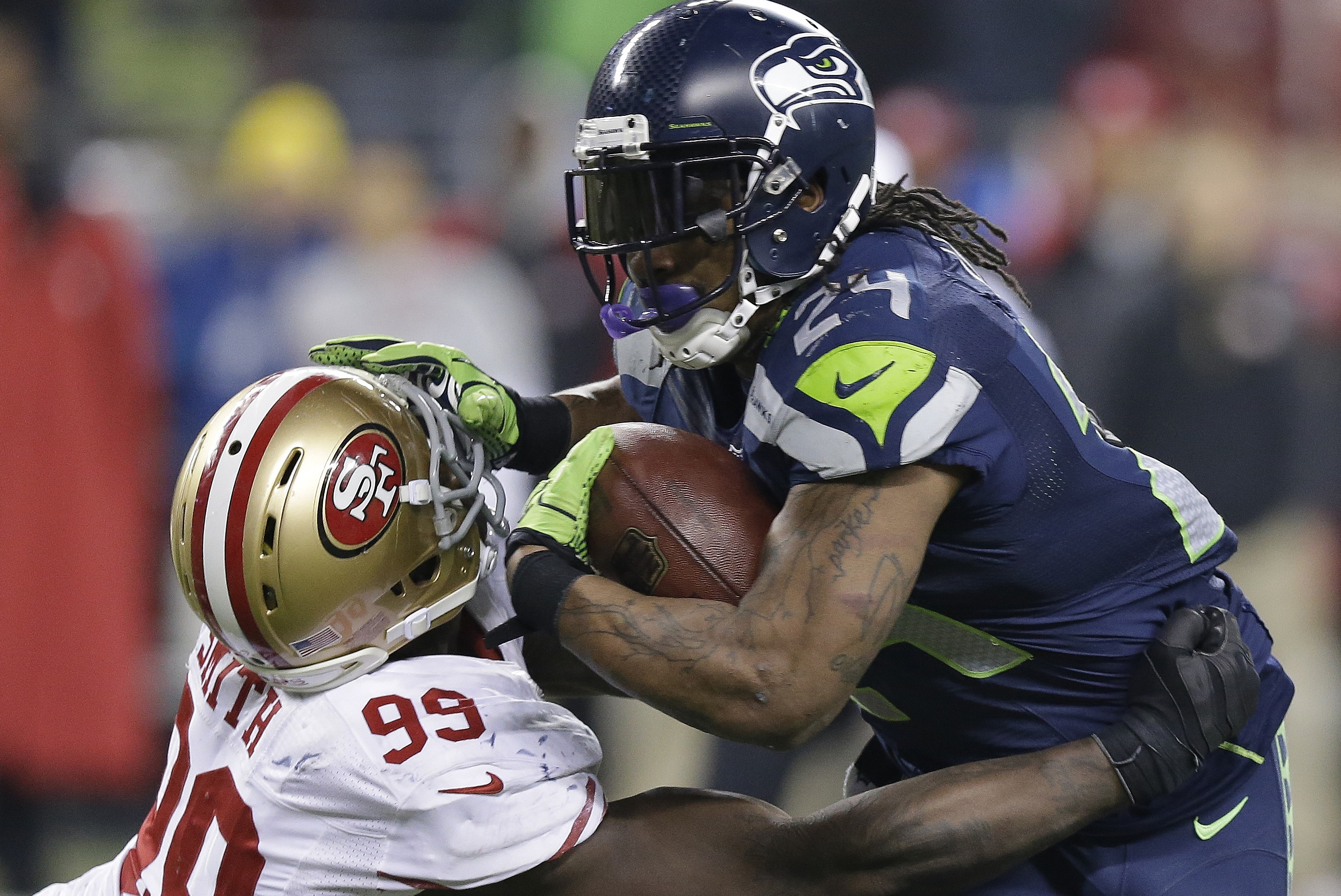 Seattle Seahawks' Marshawn Lynch tries to run past San Francisco 49ers' Aldon Smith during the second half of the NFL football NFC Championship game Sunday, Jan. 19, 2014, in Seattle. (AP Photo/Elaine Thompson)