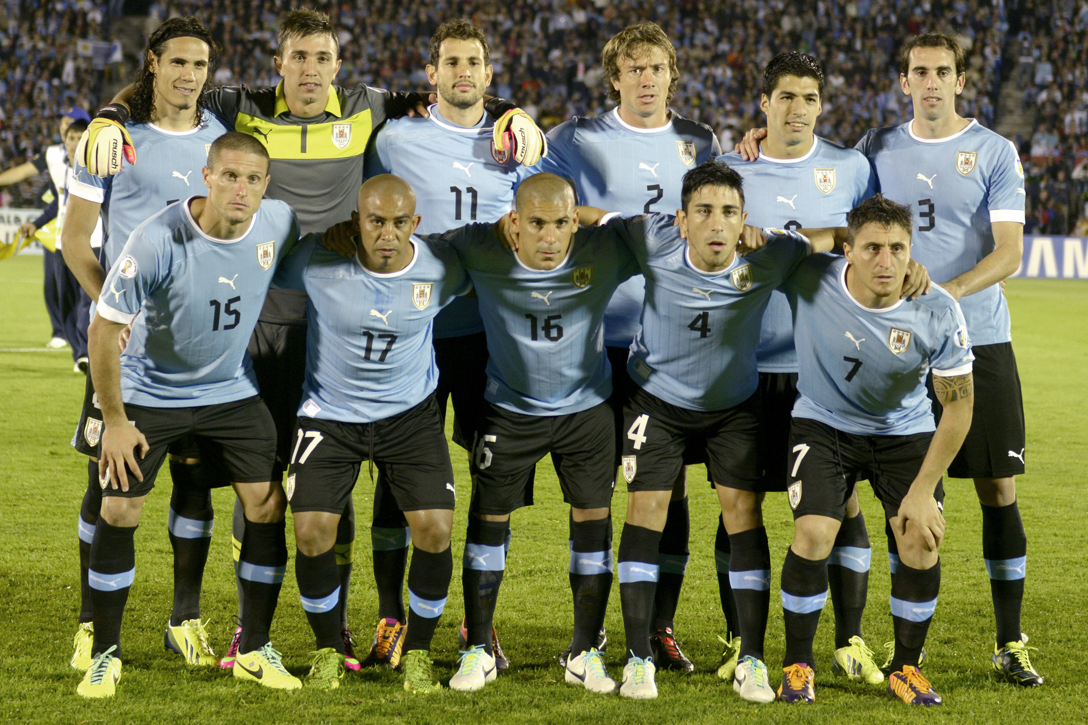 FILE - In this Oct. 15, 2013 file photo, Uruguay soccer team poses prior to the start the 2014 World Cup qualifying soccer match between Uruguay and Argentina in Montevideo, Uruguay. Foreground from left: Diego Perez, Egidio Arevalo, Maximiliano Pereira, Jorge Fucile and Cristian Rodriguez. Background from left: Edinson Cavani, Fernando Muslera, Christian Stuani, Diego Lugano, Luis Suarez and Diego Godin. The draw for the 2014 World Cup finals takes place Friday Dec. 6, 2013 near Salvador, Brazil. The 32 teams will be drawn into eight groups of four. The top two in each group will progress to the knockout stages. Twelve stadiums in twelve cities will host matches. (AP Photo/Matilde Campodonico, File)