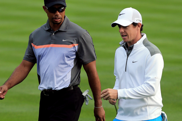 Tiger Woods from the U.S., left, talks to Rory McIlroy of Northern Ireland during the first round of the Dubai Desert Classic golf tournament in Dubai, United Arab Emirates, Thursday, Jan. 30, 2014. (AP Photo)