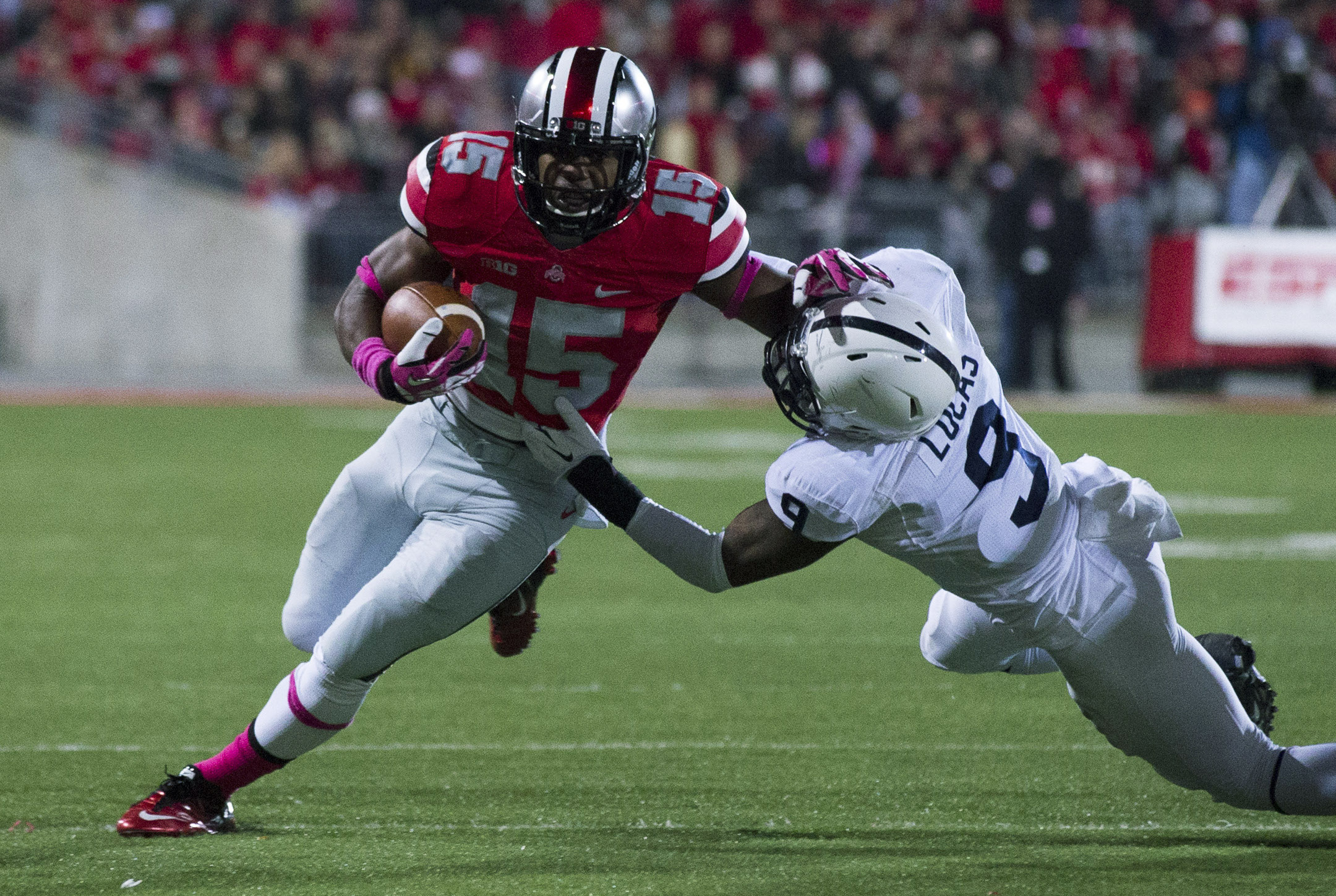 Oct 26, 2013; Columbus, OH, USA; Ohio State Buckeyes running back Ezekiel Elliott (15) breaks a tackle attempted by Penn State Nittany Lions cornerback Jordan Lucas (9) at Ohio Stadium. Mandatory Credit: Greg Bartram-USA TODAY Sports