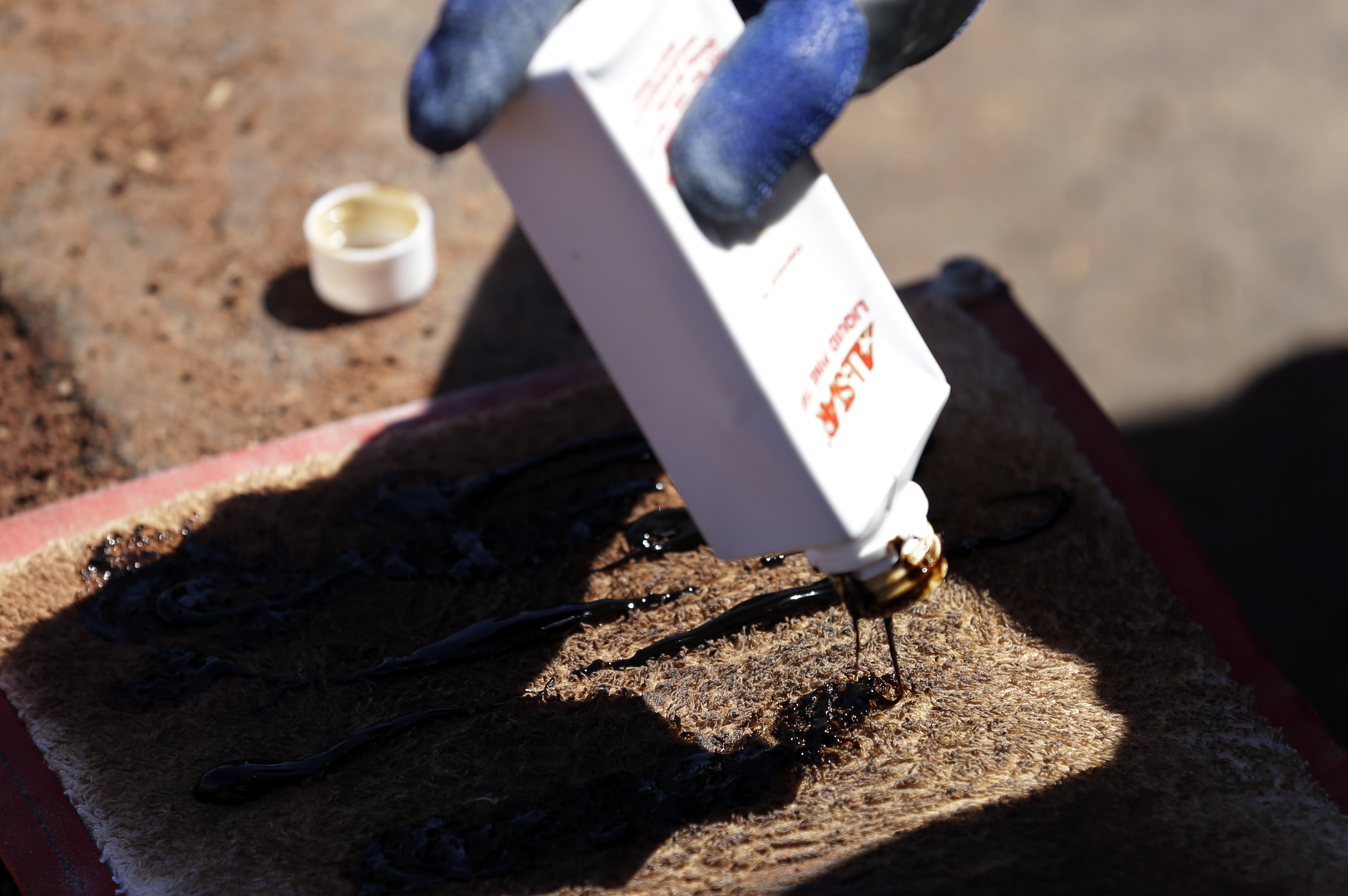 Texas Rangers official Mason McKenna applies pine tar to a bat cloth before the team plays the San Francisco Giants in an exhibition spring training baseball game Monday, March 11, 2013, in Surprise, Ariz. (AP Photo/Gregory Bull)