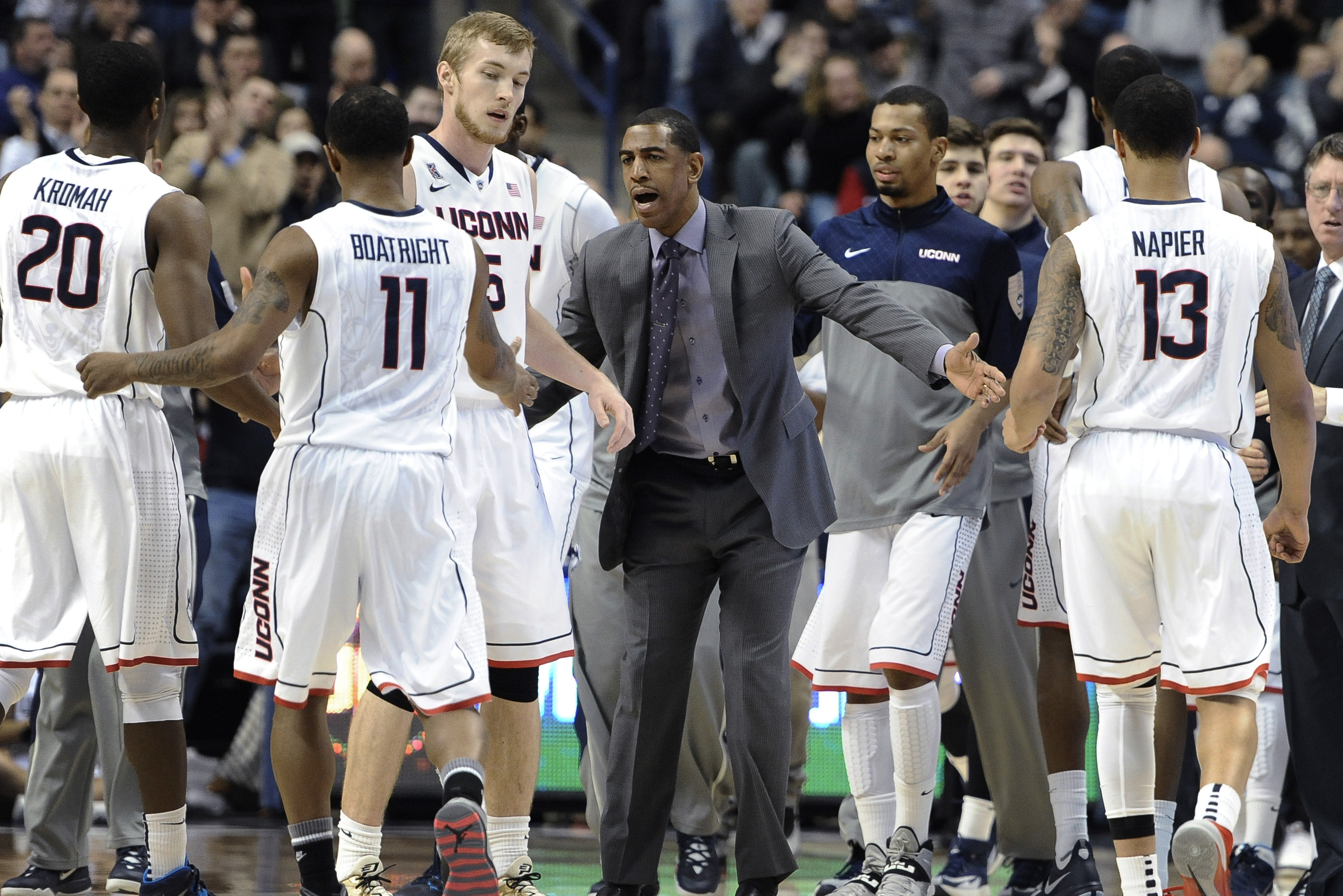 Connecticut coach Kevin Ollie, center, greets his team during a timeout in the first half of an NCAA college basketball game against Houston, Thursday, Jan. 30, 2014, in Storrs, Conn. (AP Photo/Jessica Hill)