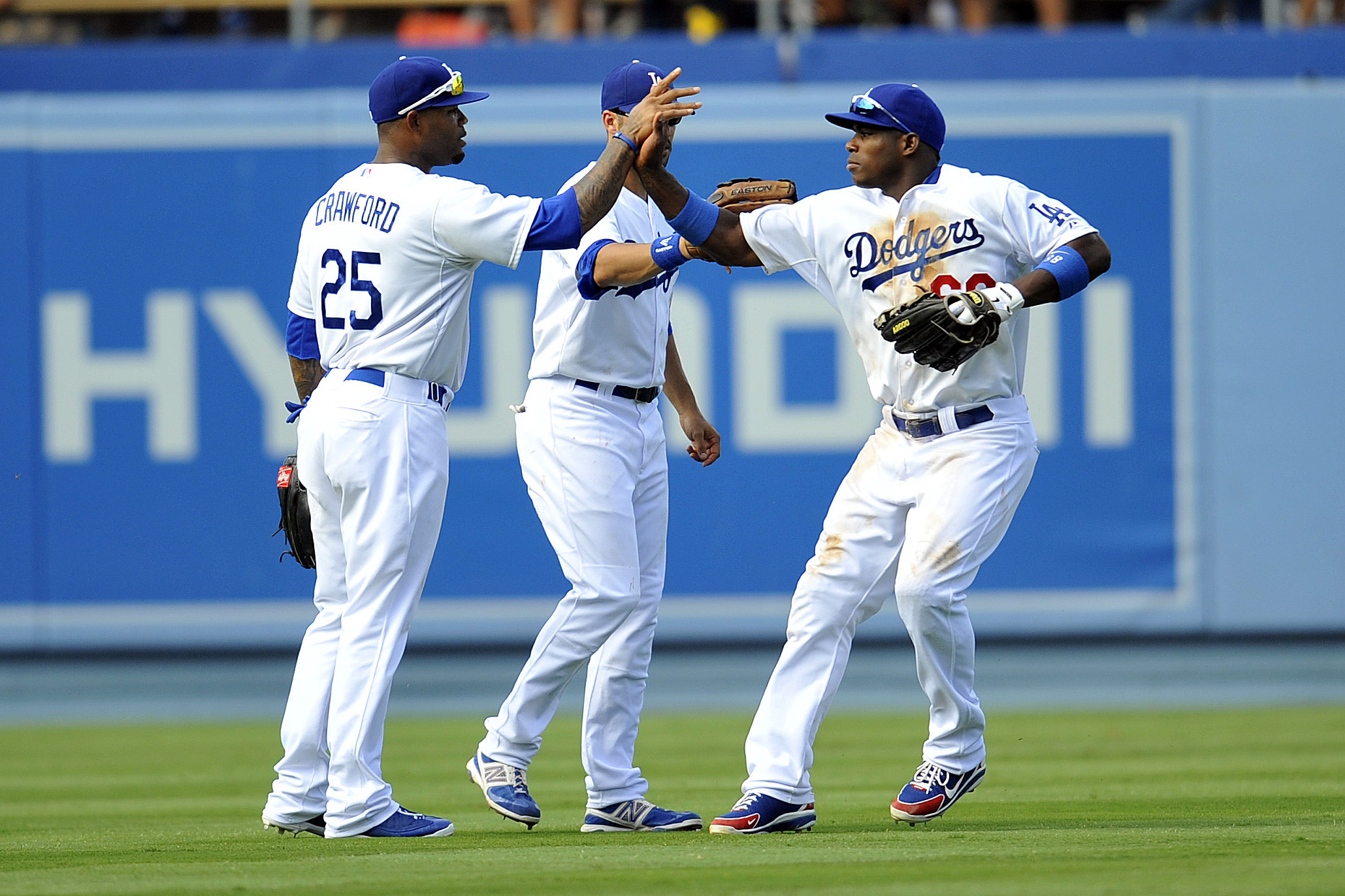 September 1, 2013; Los Angeles, CA, USA; Los Angeles Dodgers right fielder Yasiel Puig (66), left fielder Carl Crawford (25) and center fielder Andre Ethier (16) celebrate the 2-1 victory against the San Diego Padres at Dodger Stadium. Mandatory Credit: Gary A. Vasquez-USA TODAY Sports