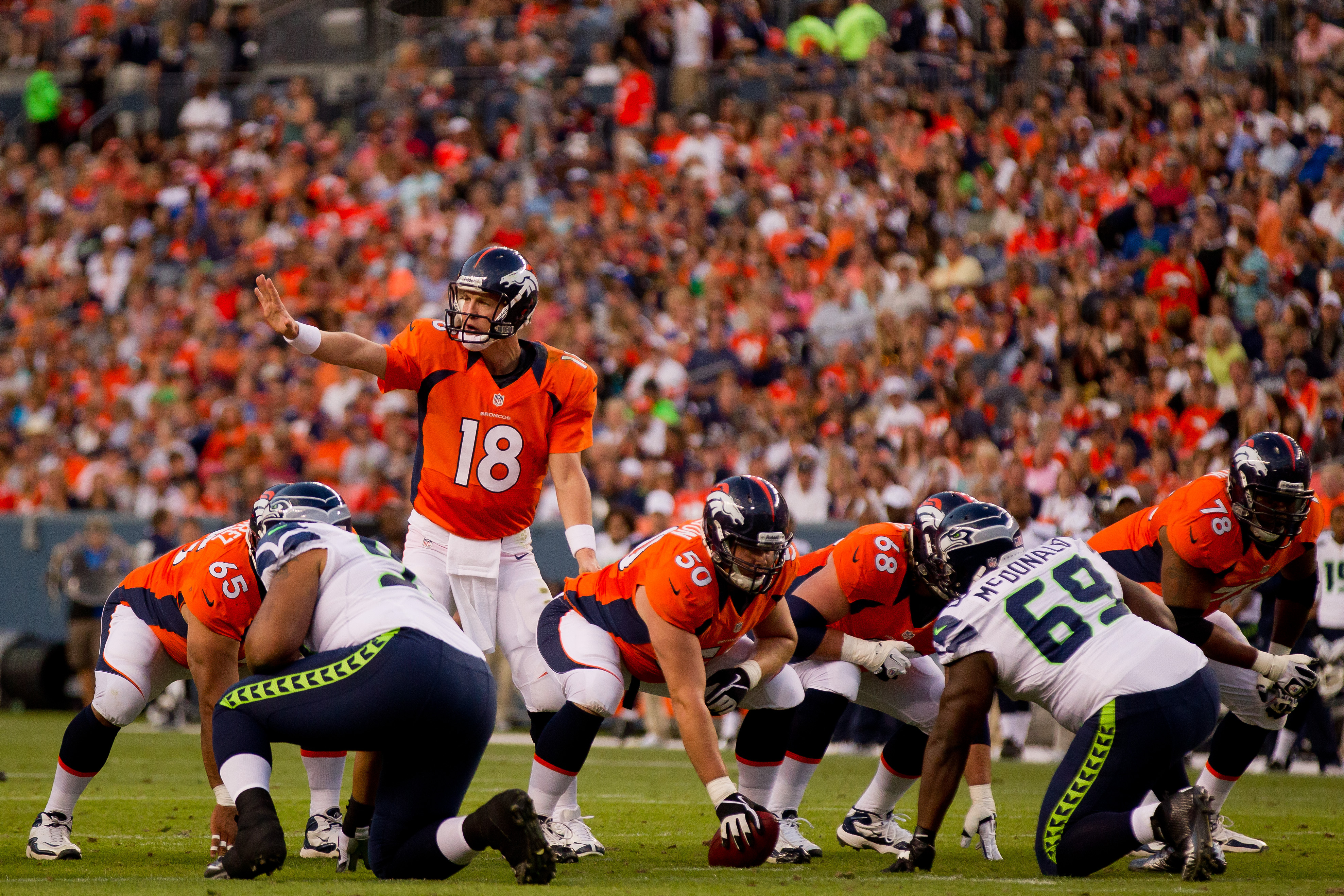 DENVER, CO - AUGUST 18:  Quarterback Peyton Manning #18 of the Denver Broncos signals from the shotgun during the first quarter against the Seattle Seahawks at Sports Authority Field Field at Mile High on August 18, 2012 in Denver, Colorado. (Photo by Justin Edmonds/Getty Images)