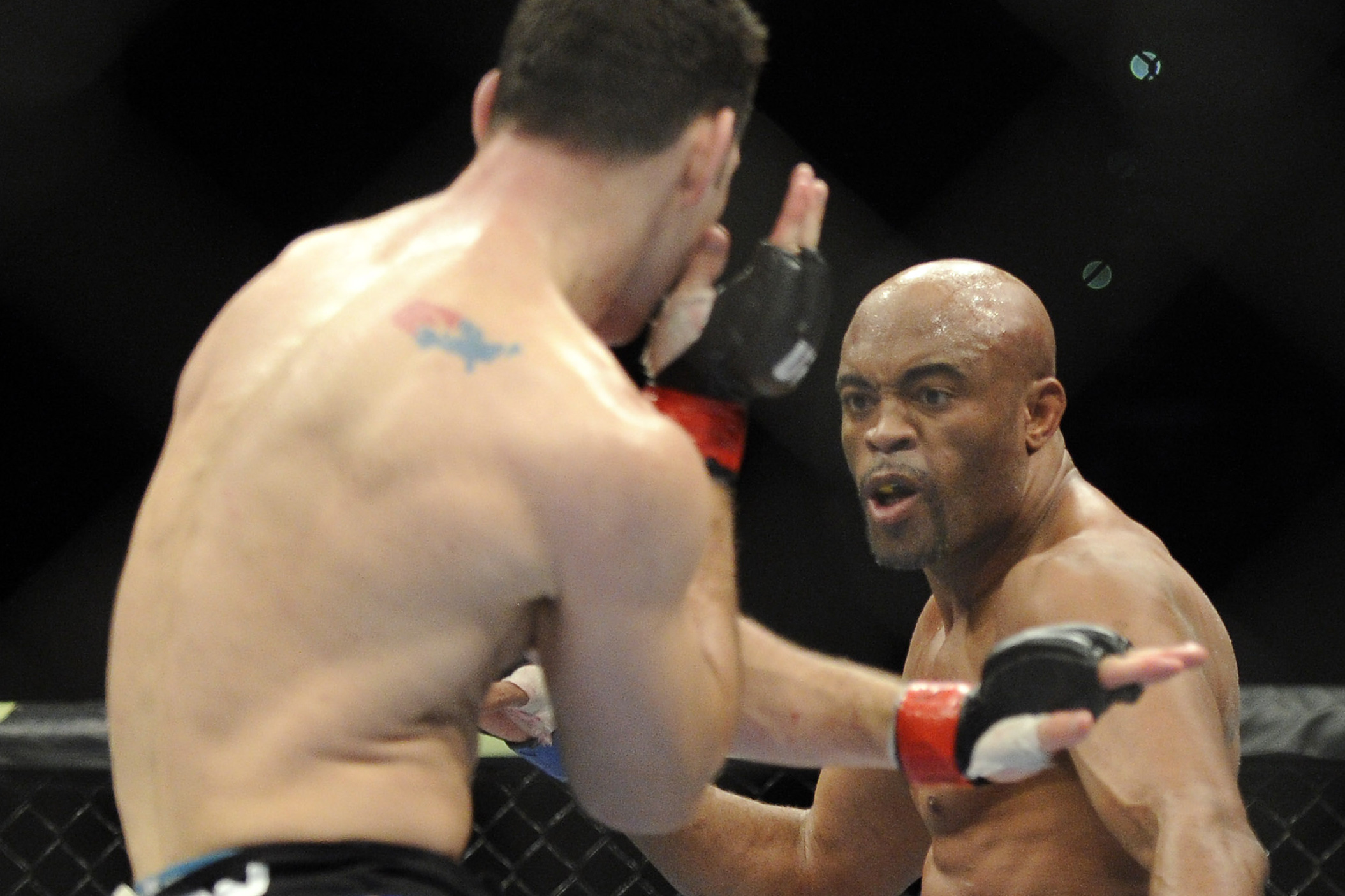 Anderson Silva, right, of Brazil, prepares to kick Chris Weidman of Baldwin, N.Y., during the UFC 168 mixed martial arts middleweight championship bout on Saturday, Dec. 28, 2013, in Las Vegas. Weidman won during the second round by a technical knock out after Silva was injured. (AP Photo/David Becker)
