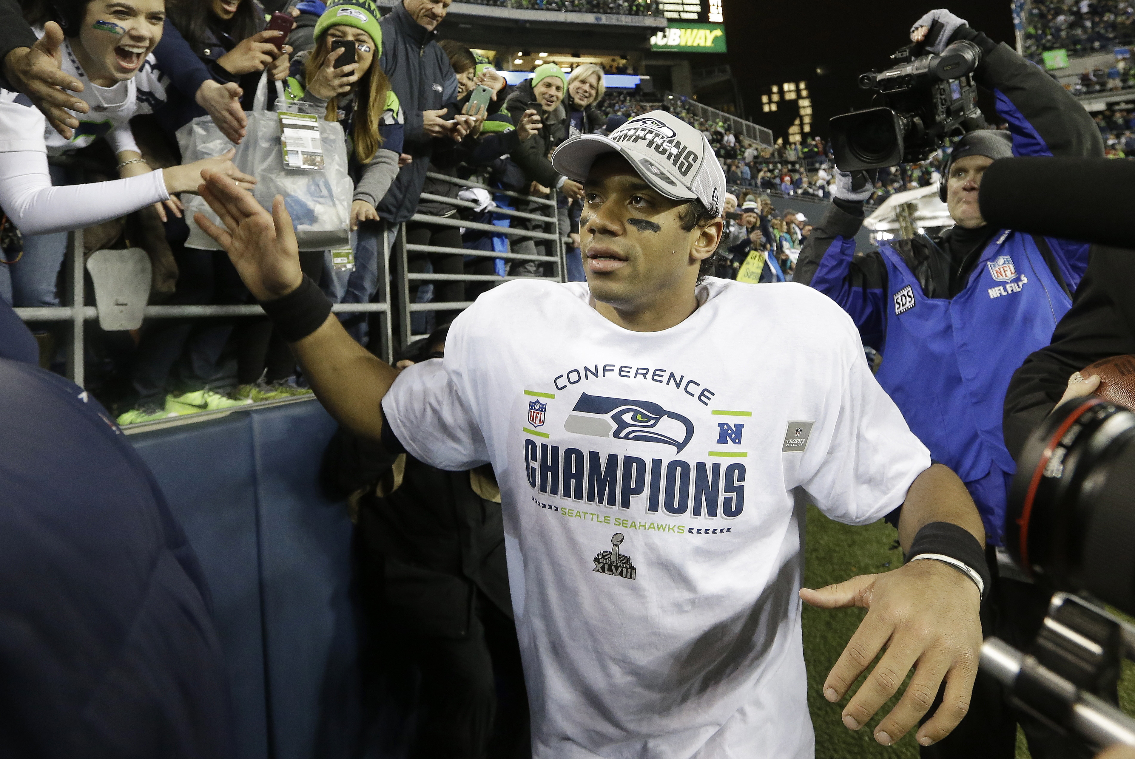 Seattle Seahawks' Russell Wilson celebrates with fans after the NFL football NFC Championship game against the San Francisco 49ers, Sunday, Jan. 19, 2014, in Seattle. The Seahawks won 23-17 to advance to Super Bowl XLVIII. (AP Photo/Elaine Thompson)