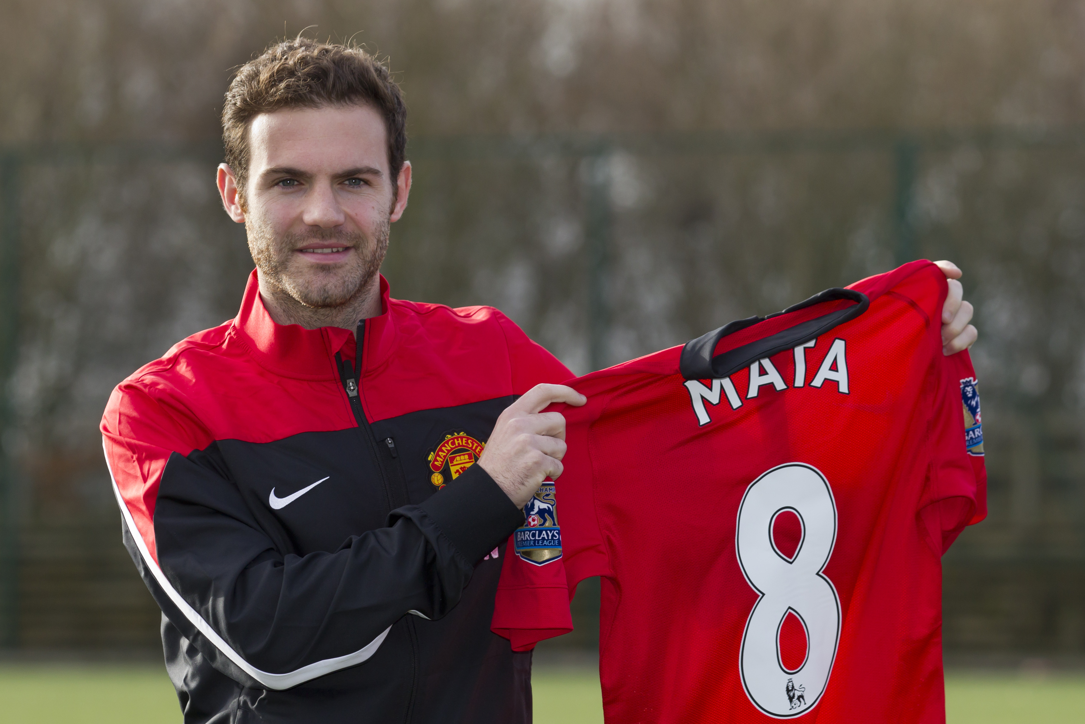 Manchester United's new signing Juan Mata displays his new shirt before a press conference at the team's Carrington training ground, Manchester, England, Monday, Jan. 27, 2014. With Manchester United in danger of missing out on the Champions League next season, Juan Mata's arrival at Old Trafford for a club record fee of 37.1 million pounds ($61.2 million) is certainly an emergency move. But it also marks the first step in the rebuilding process of England's most titled club. After a botched transfer campaign last summer that was followed by the club's lackluster first half of the season, United now looks determined to allow manager David Moyes the opportunity to build his own team.(AP Photo/Jon Super)