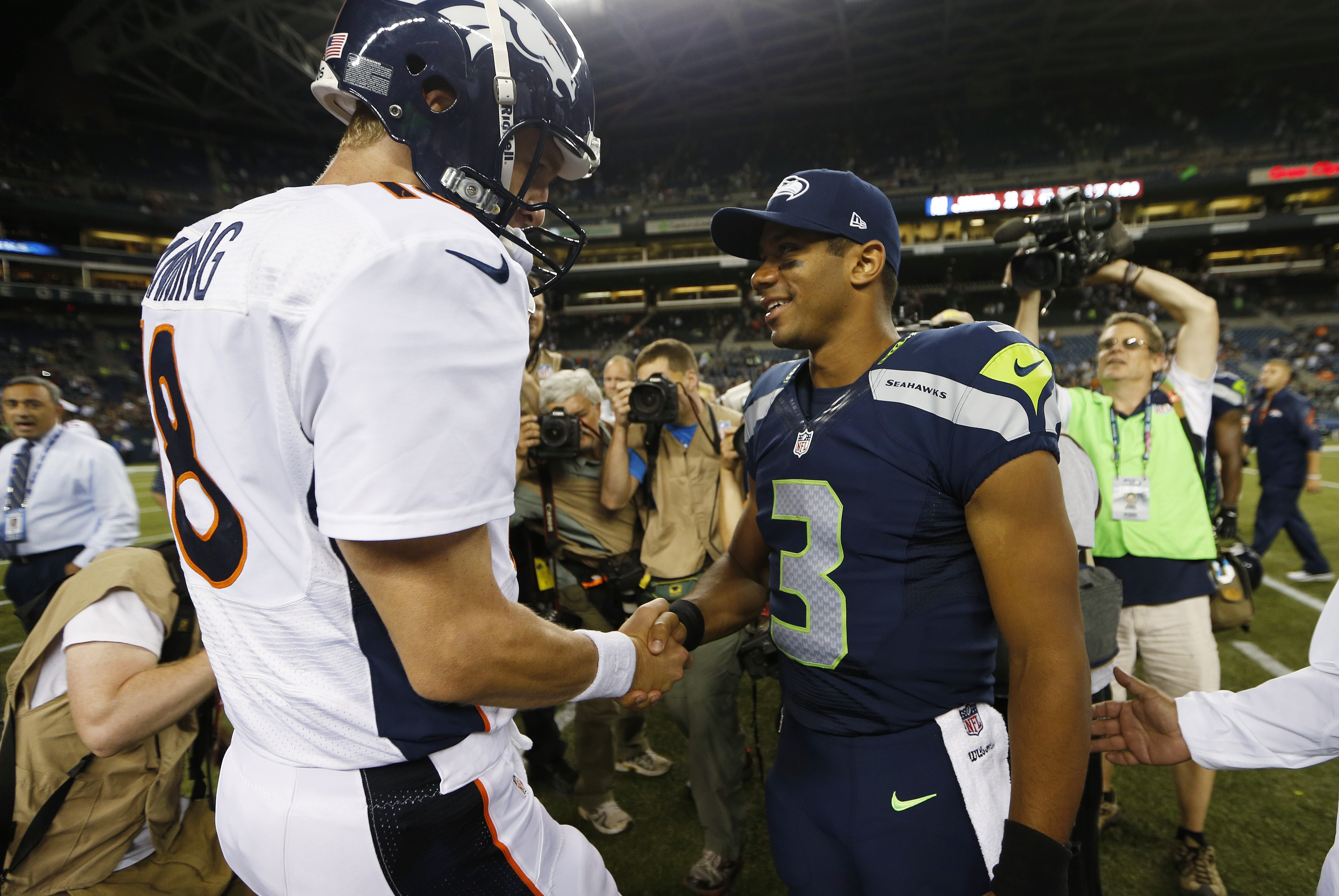 Seattle Seahawks quarterback Russell Wilson (3) shakes hands with Denver Broncos quarterback Peyton Manning, left, after the Seahawks beat the Broncos 40-10, in preseason NFL football game, Saturday, Aug. 17, 2013, in Seattle. (AP Photo/John Froschauer)