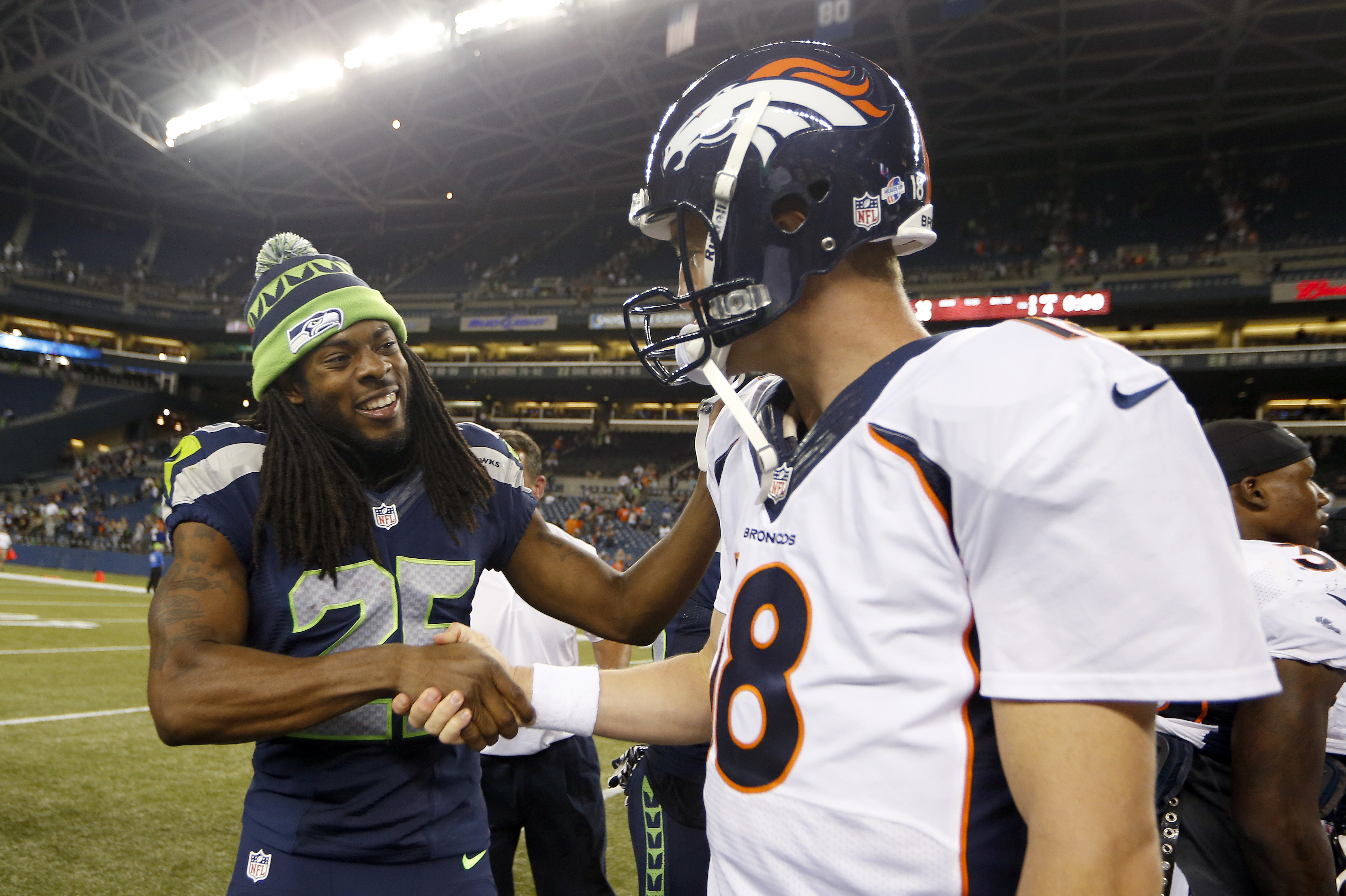 In this photo taken Aug. 17, 2013, Seattle Seahawks cornerback Richard Sherman, (25) shakes hands with Denver Broncos quarterback Peyton Manning, right, after the Seahawks beat the Broncos 40-10, in a preseason NFL football game in Seattle. The two teams square off in Super Bowl XLVIII on Sunday, Feb. 2, 2014, in East Rutherford, N.J.  (AP Photo/John Froschauer)