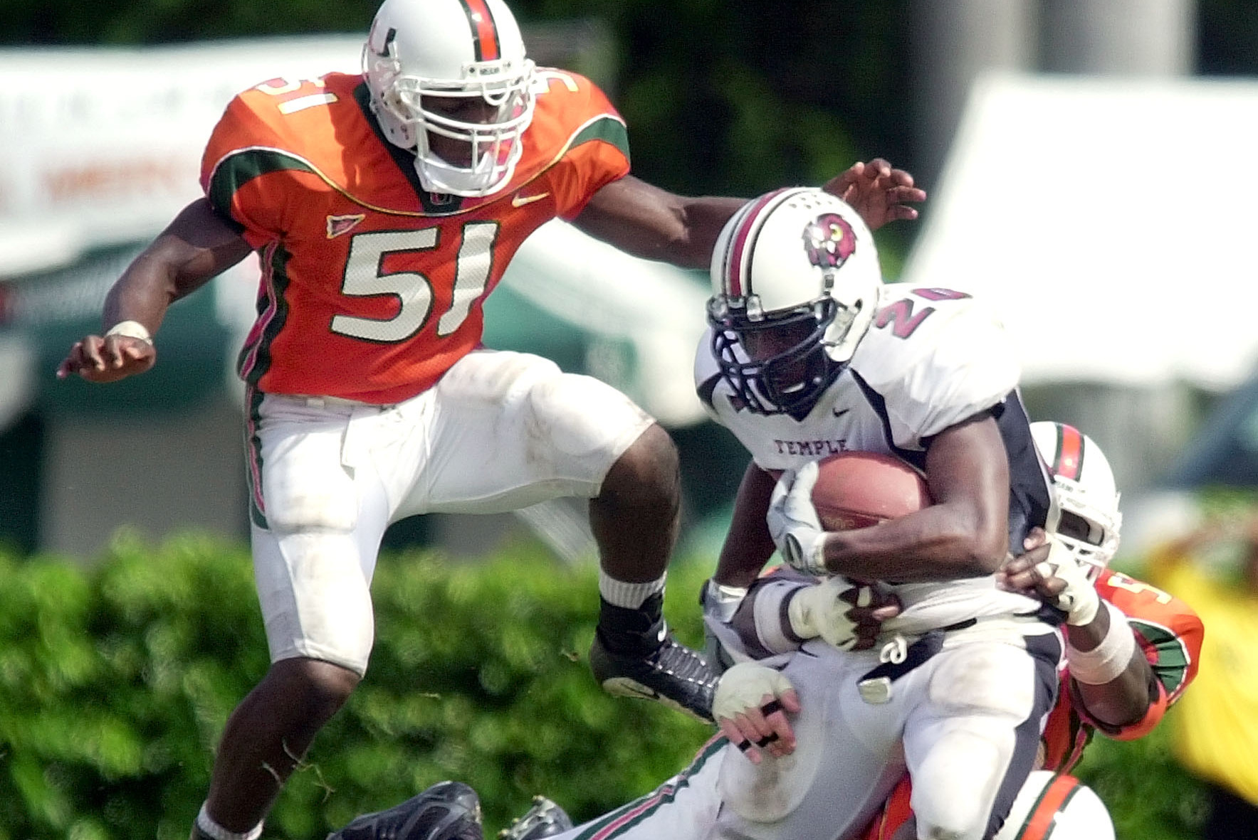 Temple's Lester Trammer (20) fights for extra yardage against Miami's Matt Walters (91) Jarrell Weaver, back, and Jonathan Vilma (51) during the second half Saturday Nov. 3, 2001, at the Orange Bowl in Miami. (AP Photo/Tony Gutierrez)