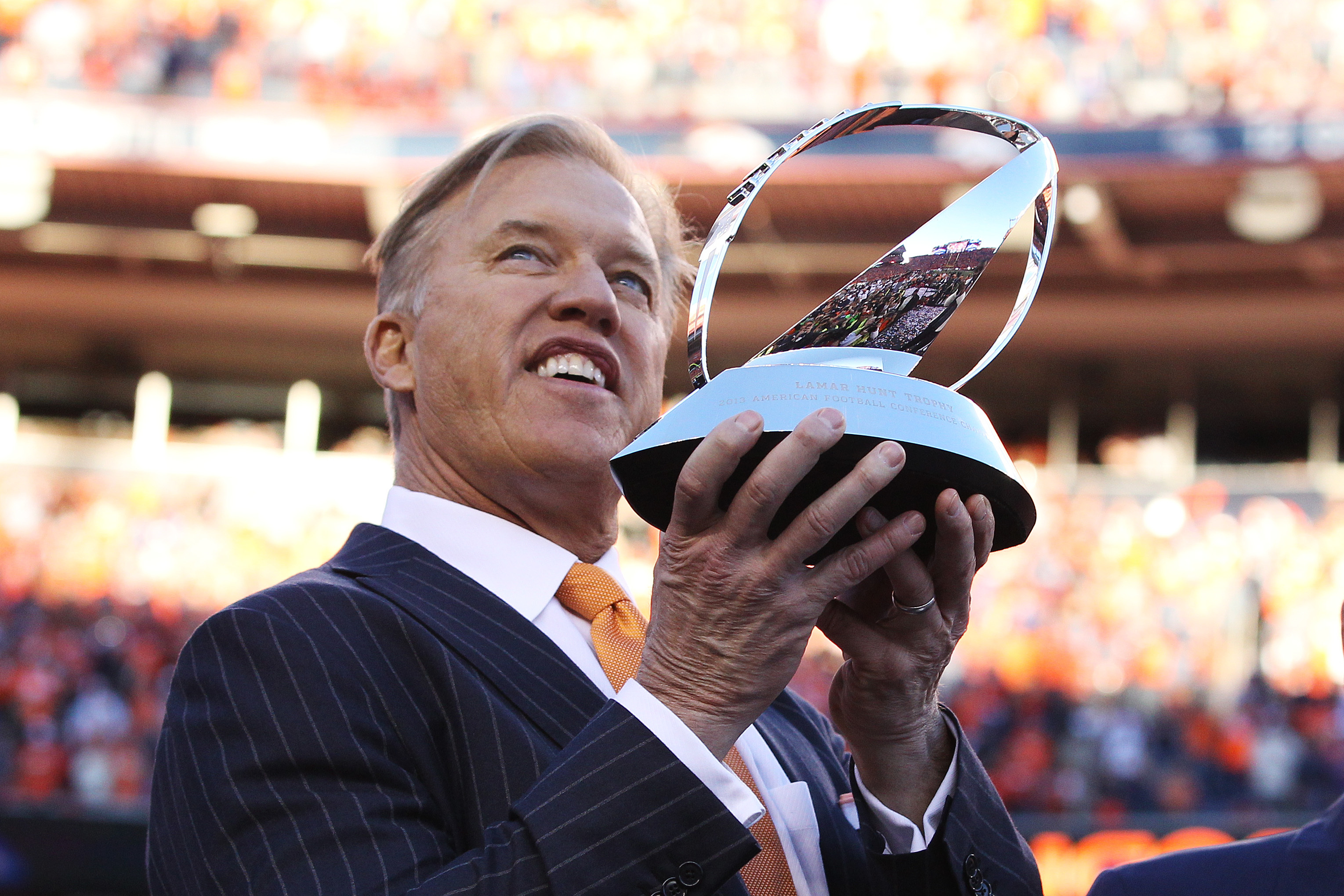 DENVER, CO - JANUARY 19:  John Elway, executive vice president of football operations for the Denver Broncos, celebrates with the Lamar Hunt Trophy after they defeated the New England Patriots 26 to 16 in the AFC Championship game at Sports Authority Field at Mile High on January 19, 2014 in Denver, Colorado.  (Photo by Doug Pensinger/Getty Images)