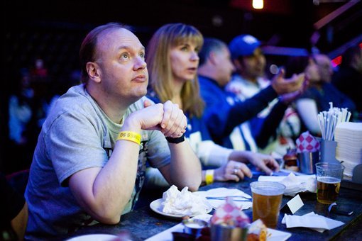 FILE - In this Feb. 5, 2012, file photo, Ron Blydenburgh, of Hampton Bays, N.Y., watches the broadcast of the 2012 NFL football Super Bowl. You don't have to be a football player to be a part of the action on Super Bowl Sunday, Feb 3, 2013. Coca-Cola is asking people to vote for an online match between three groups competing in a desert for a Coke on Game Day. Pepsi and Toyota are using viewers' photos in their ads. Audi let people choose the end of its Super Bowl ad, while Lincoln based its spot on more 6,000 tweets from fans about their road  (AP Photo/John Minchillo, File)