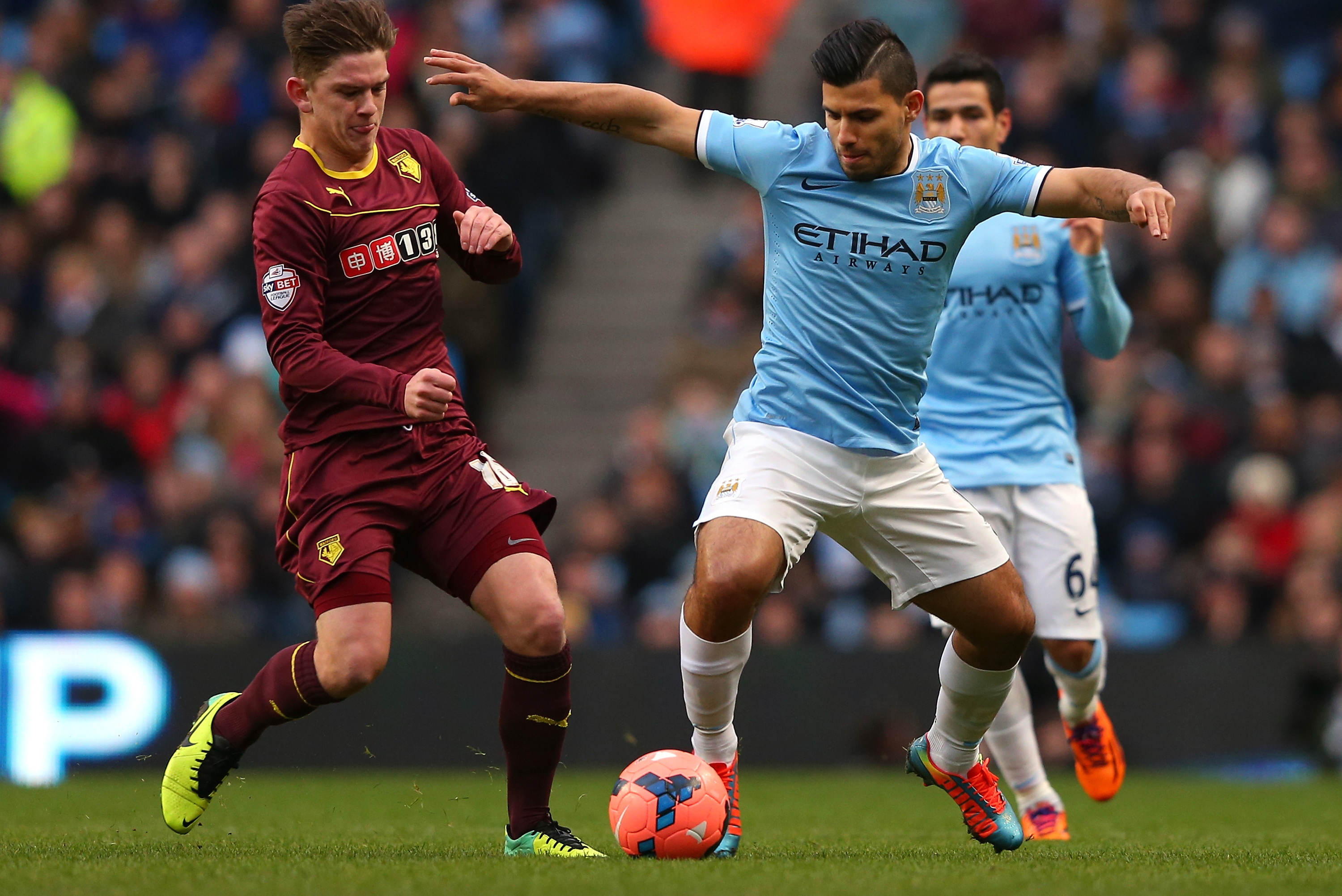 MANCHESTER, ENGLAND - JANUARY 25:  Sergio Aguero of Manchester City holds off a challenge from Sean Murray of Watford during the FA Cup Fourth Round match sponsored by Budweiser between Manchester City and Watford at Etihad Stadium on January 25, 2014 in Manchester, England.  (Photo by Alex Livesey/Getty Images)