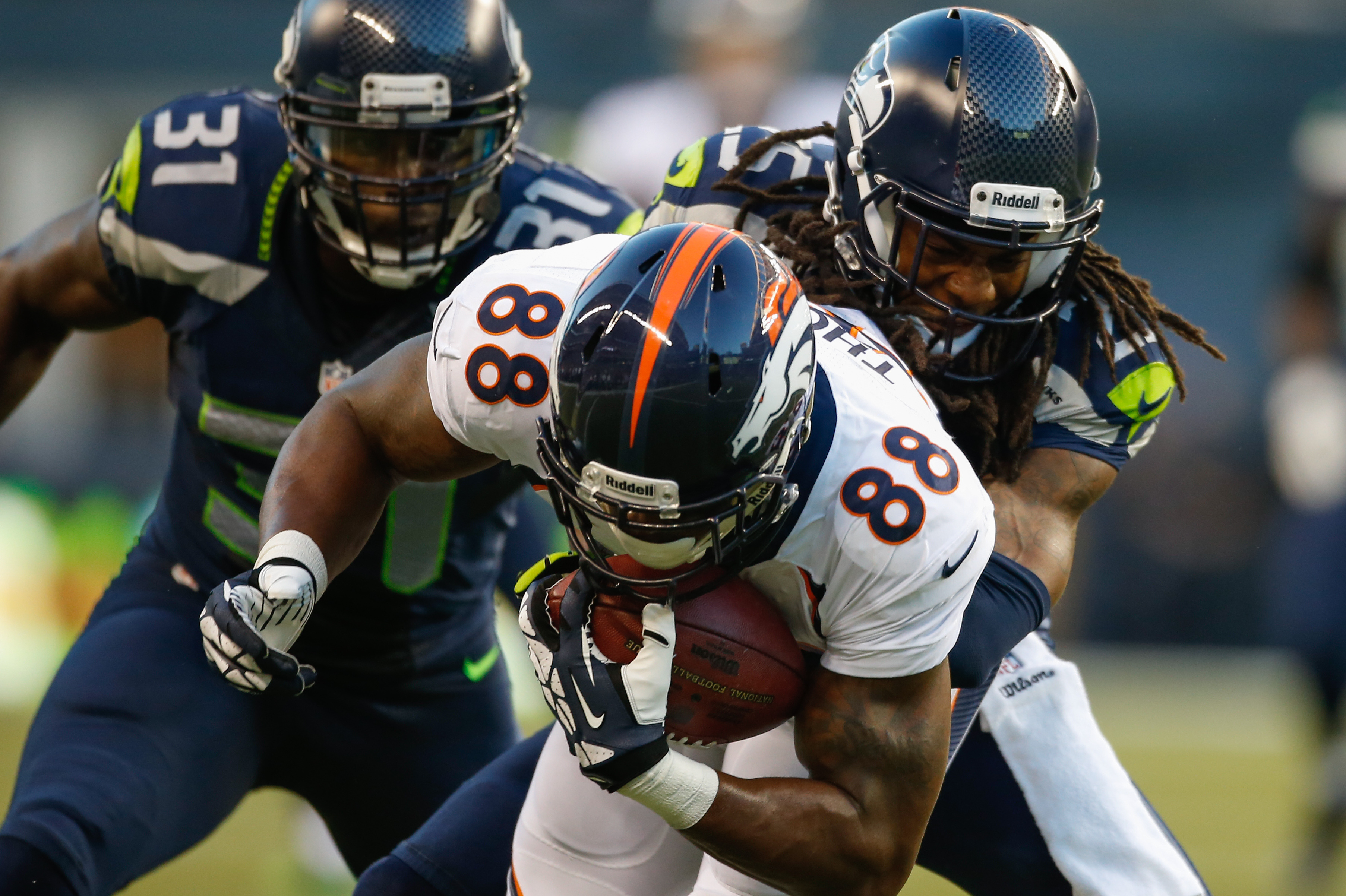SEATTLE, WA - AUGUST 17:  Cornerback Richard Sherman #25 of the Seattle Seahawks tackles wide receiver Demaryius Thomas #88 of the Denver Broncos at CenturyLink Field on August 17, 2013 in Seattle, Washington.  (Photo by Otto Greule Jr/Getty Images)