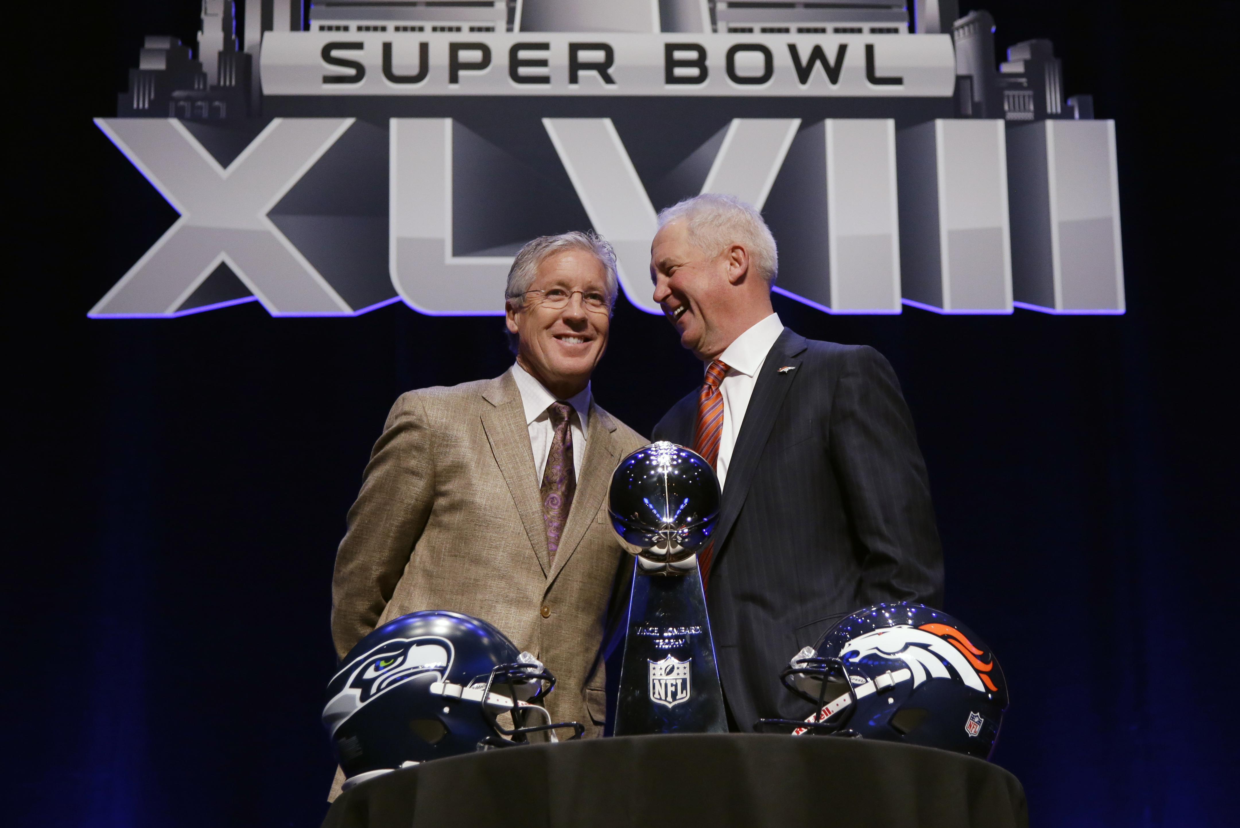 Seattle Seahawks head coach Pete Carroll, left, and Denver Broncos head coach John Fox laugh as they pose behind the Vince Lombardi Trophy before speaking at a news conference Friday, Jan. 31, 2014, in New York. The Seahawks and the Broncos are scheduled to play in the NFL Super Bowl XLVIII football game on Sunday, Feb. 2, at MetLife Stadium in East Rutherford, N.J. (AP Photo/Matt Slocum)