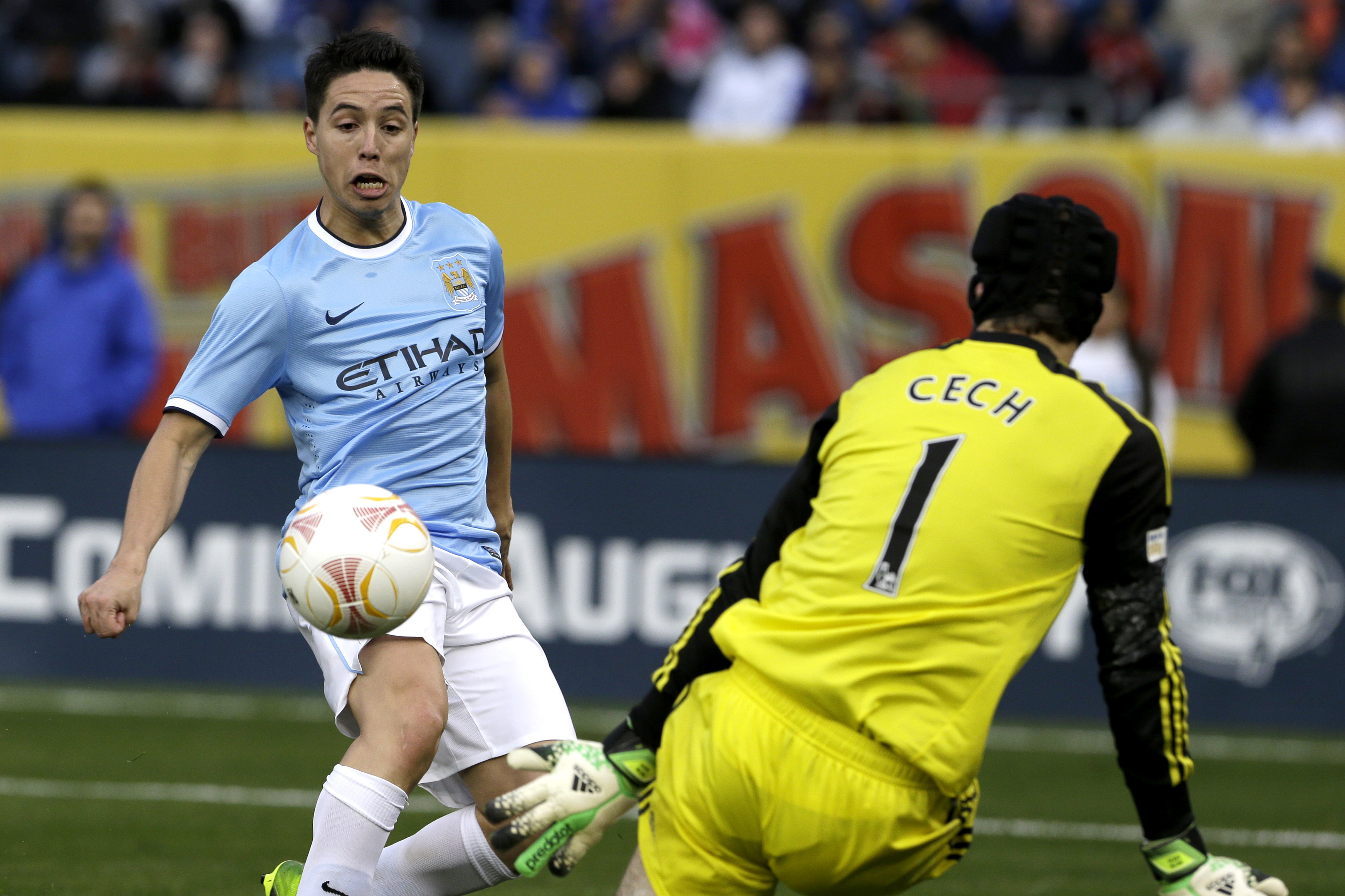 Manchester City midfielder Samir Nasri, left, scores a goal against Chelsea goalkeeper Petr Cech during the second half of an exhibition international friendly soccer match, Saturday, May 25, 2013, at Yankee Stadium in New York. (AP Photo/Julio Cortez)