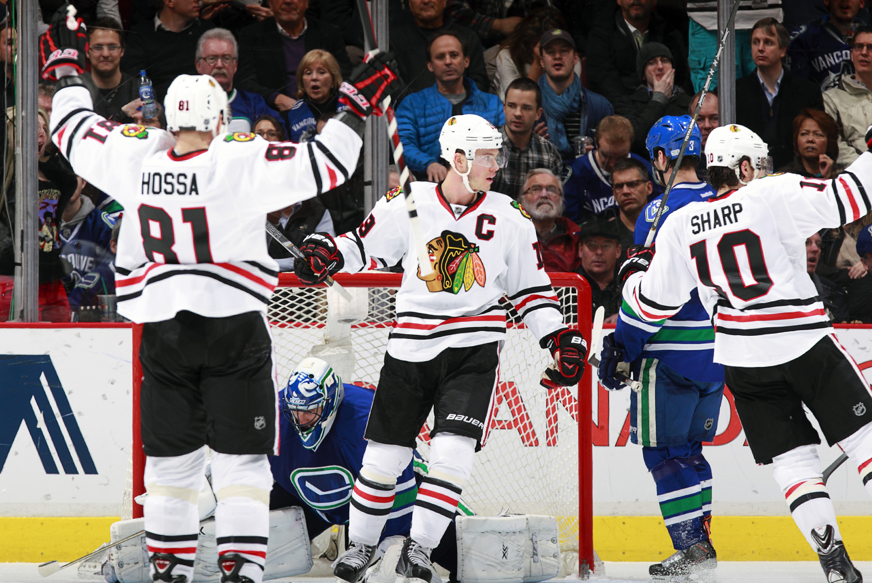 VANCOUVER, BC - JANUARY 29:  Marian Hossa #81 and Jonathan Toews #19 celebrates a goal by Patrick Sharp #10 of the Chicago Blackhawks against Roberto Luongo #1 of the Vancouver Canucks as Kevin Bieksa #3 of the Canucks turns away during their NHL game at Rogers Arena January 29, 2014 in Vancouver, British Columbia, Canada. Chicago won 5-2.  (Photo by Jeff Vinnick/NHLI via Getty Images)