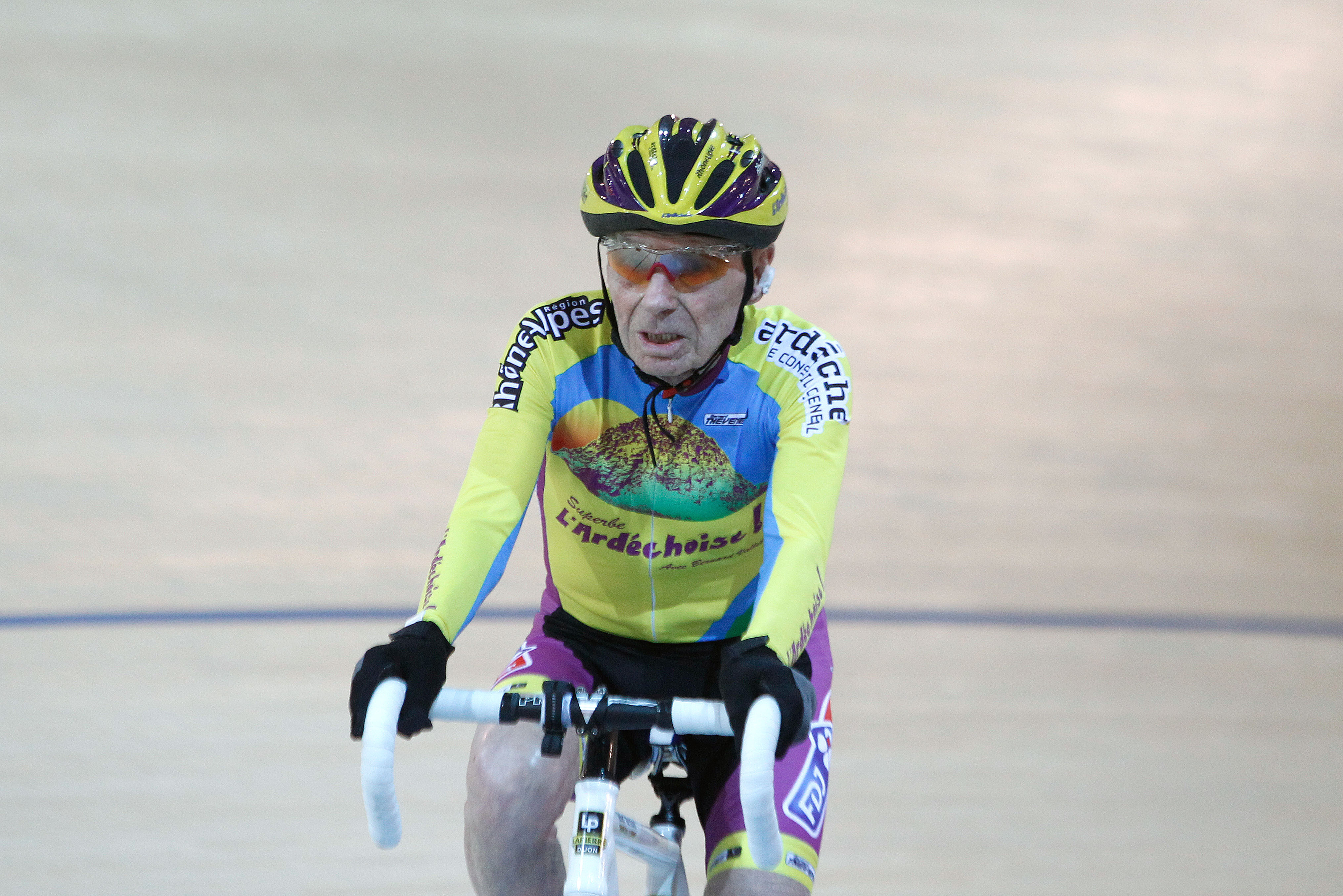 French cyclist Robert Marchand, aged 102, cycles in a bid to beat his record for distance cycled in one hour, at the velodrome of Saint-Quentin en Yvelines, outside Paris, Friday, Jan. 31, 2014. The 102-year-old broke his own world record in the over-100s category Friday, riding 26.927 kilometers (16.7 miles) in one hour, more than 2.5 kilometers better than his previous best time in the race against the clock two years ago. (AP Photo/Thibault Camus)