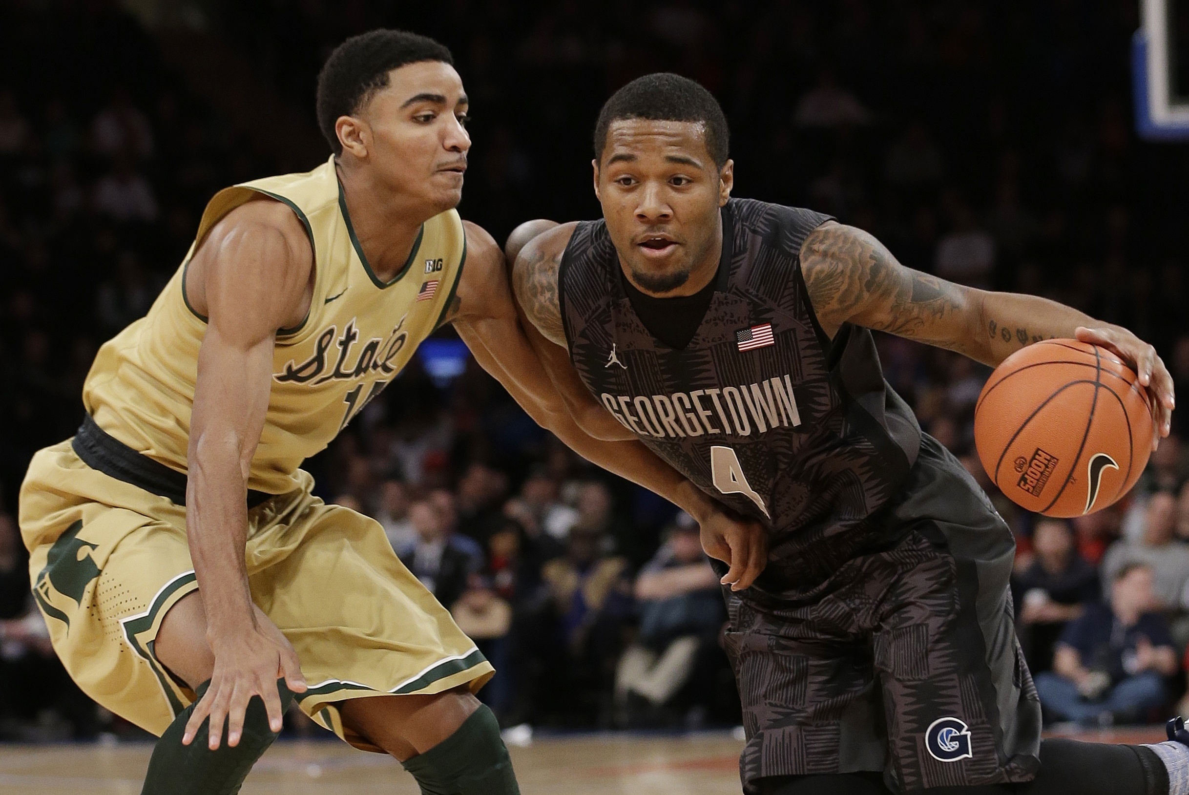 Michigan State's Gary Harris (14) defends Georgetown's D'Vauntes Smith-Rivera (4) during the first half of an NCAA college basketball game Saturday, Feb. 1, 2014, in New York. (AP Photo/Frank Franklin II)