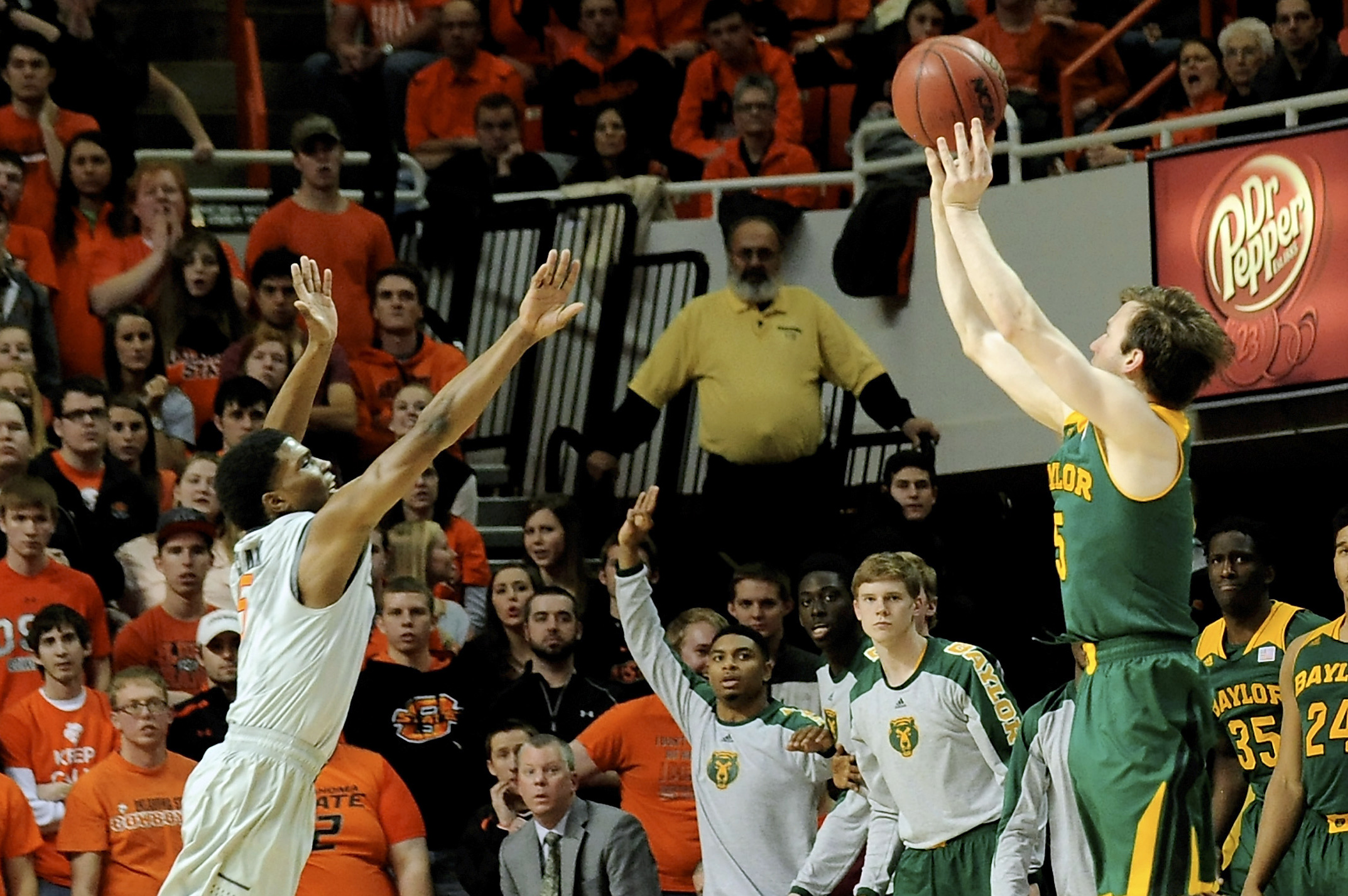 Baylor guard Brady Heslip, right, shoots a 3-point shot over Oklahoma State guard Stevie Clark, left, during the second half of an NCAA college basketball game in Stillwater, Okla., Saturday, Feb. 1, 2014. Heslip scored 20 points in their 76-70 win. (AP Photo/Brody Schmidt)