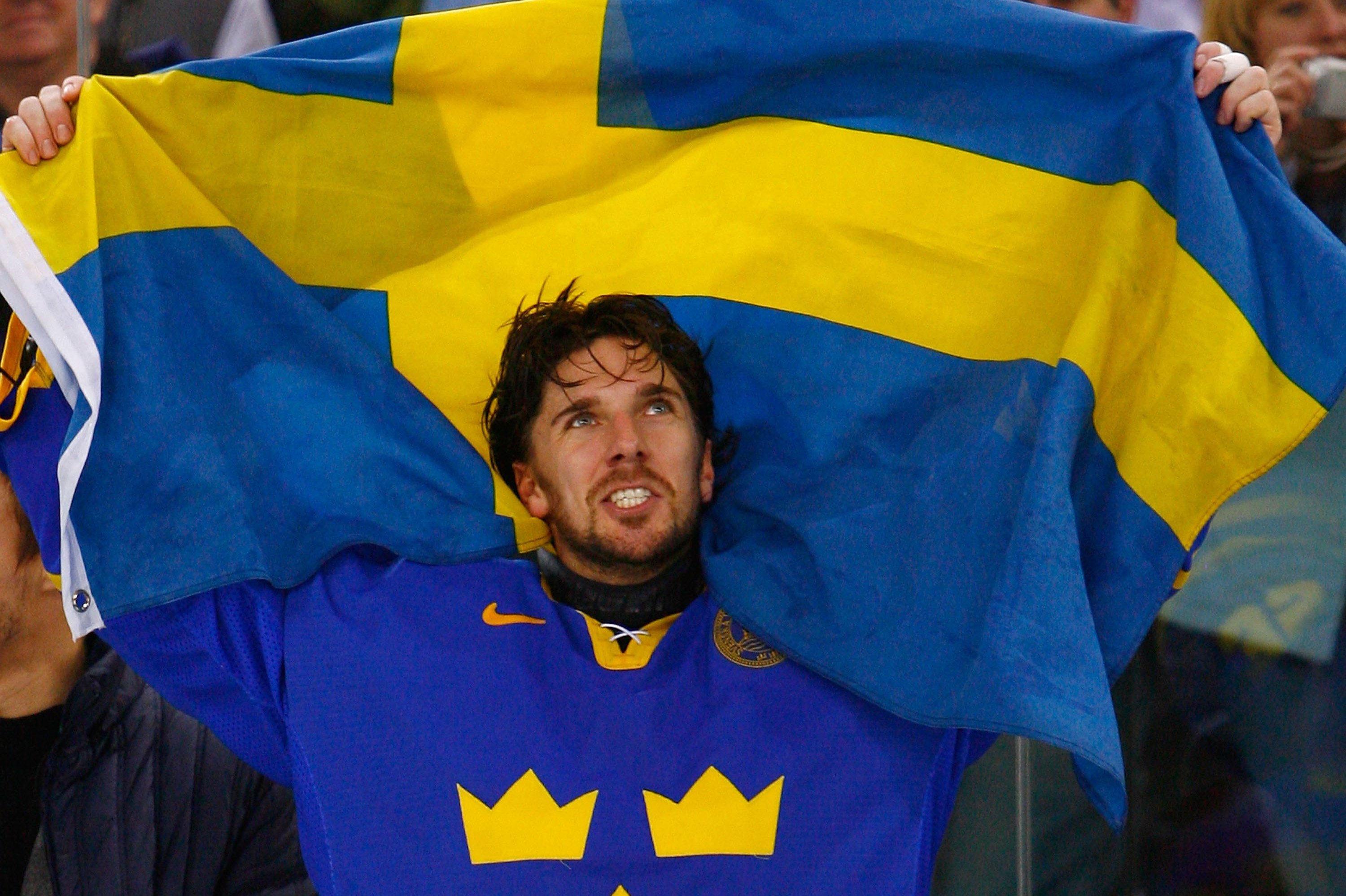 TURIN, ITALY - FEBRUARY 26:  Henrik Lundqvist #35 of Sweden waves the Swedish flag after Sweden defeated Finland 3-2 to win the gold medal during the final of the men's ice hockey match between Finland and Sweden during Day 16 of the Turin 2006 Winter Olympic Games on February 26, 2006 at the Palasport Olimpico in Turin, Italy.  (Photo by Al Bello/Getty Images)