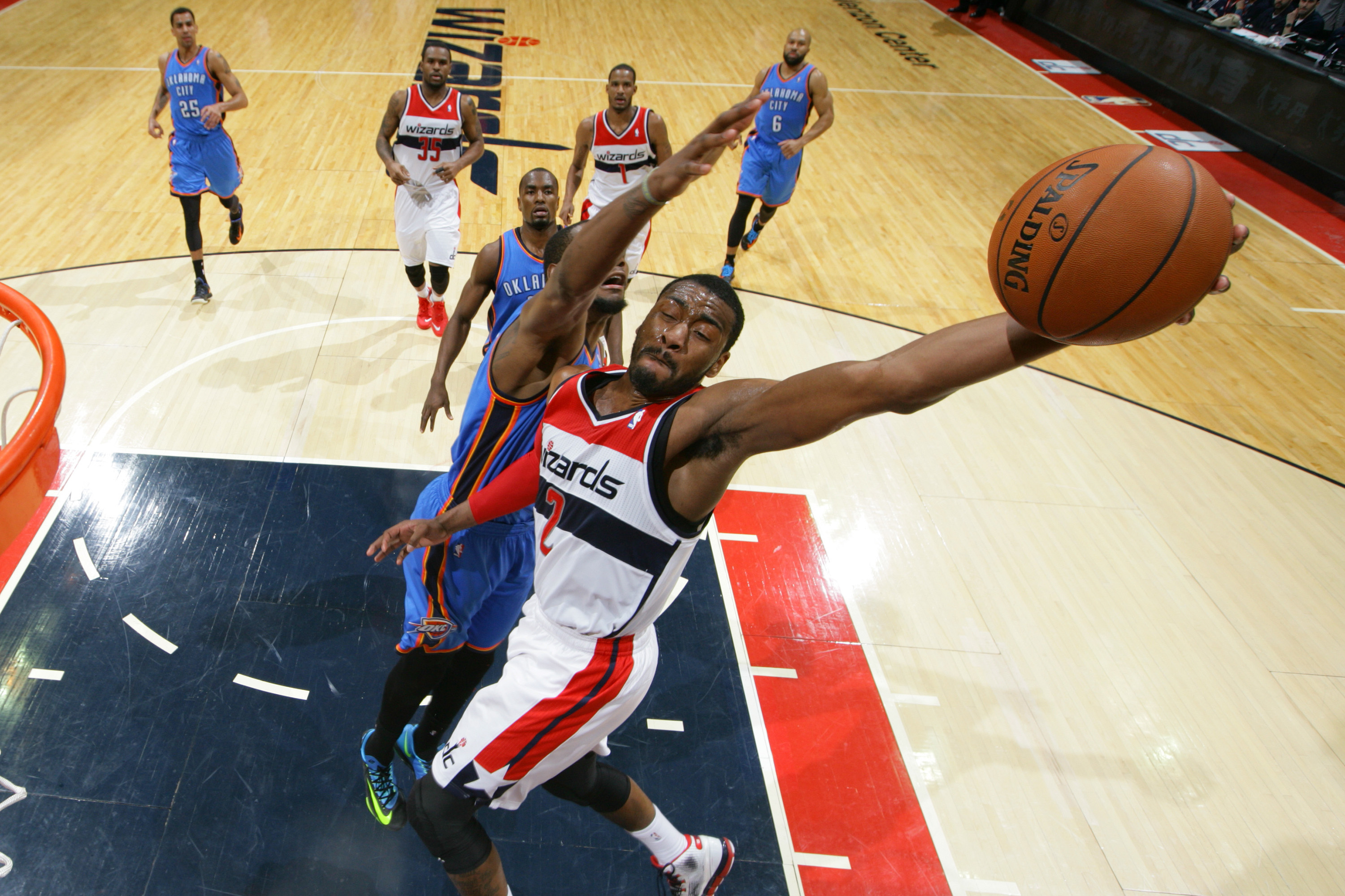 WASHINGTON, DC - FEBRUARY 2: John Wall #2 of the Washington Wizards dunks against Kevin Durant #35 of the Oklahoma City Thunder at the Verizon Center on February 2, 2014 in Washington, DC. NOTE TO USER: User expressly acknowledges and agrees that, by downloading and or using this photograph, User is consenting to the terms and conditions of the Getty Images License Agreement. Mandatory Copyright Notice: Copyright 2014 NBAE (Photo by Ned Dishman/NBAE via Getty Images)