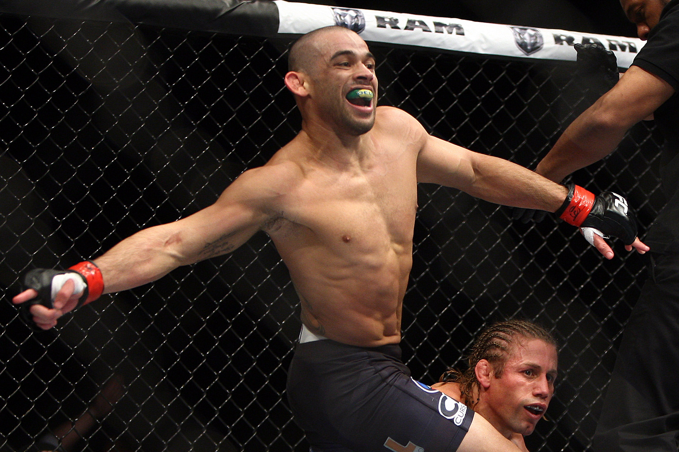 Renan Barao, left, of Brazil celebrates after the official called the fight against Urijah Faber of Sacramento, CA during the first  round of the Ultimate Fighting Bantamweight Championship Mixed Martial Arts bout in Newark, N.J. on Saturday, Feb. 1, 2014. Barao won after referee Herb Dean called the fight in the first round. (AP Photo/Tim Larsen)