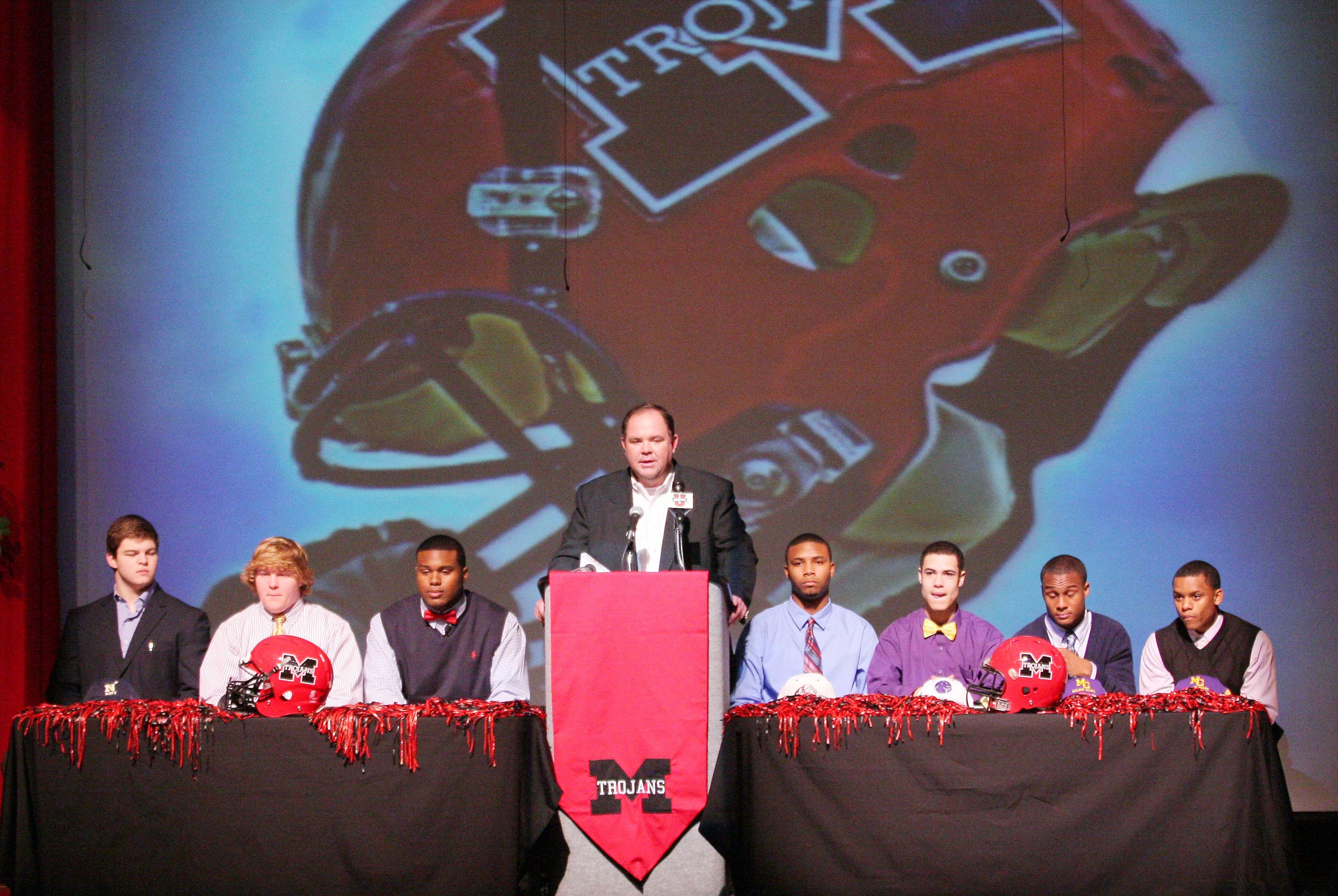 Feb 6, 2013; Muscle Shoals, AL, USA; Muscle Shoals high school football coach Scott Basden talks to the audience while standing between the members of his football team preparing to sign college football letter of intents on National Signing Day.  From left : Blake Copeland (Navy) , Brian Kilpatrick (Bethel College) , Dee Liner (Alabama) , Javian Ramson (Samford) , Levi Fell (UNA) Tyler Jackson (Miles College) and Jamarcus Nance (Miles College). Mandatory Credit: Marvin Gentry-USA TODAY Sports