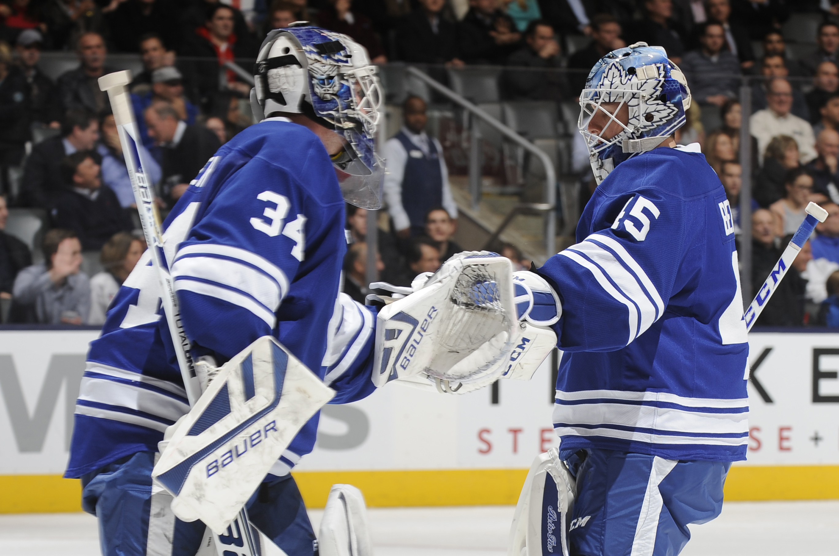 TORONTO, ON - NOVEMBER 25:  James Reimer #34 of the Toronto Maple Leafs skates past teammate Jonathan Bernier #45 after being pulled in the third period during NHL game action against the Columbus Blue Jackets November 25, 2013 at the Air Canada Centre in Toronto, Ontario, Canada. (Photo by Graig Abel/NHLI via Getty Images)