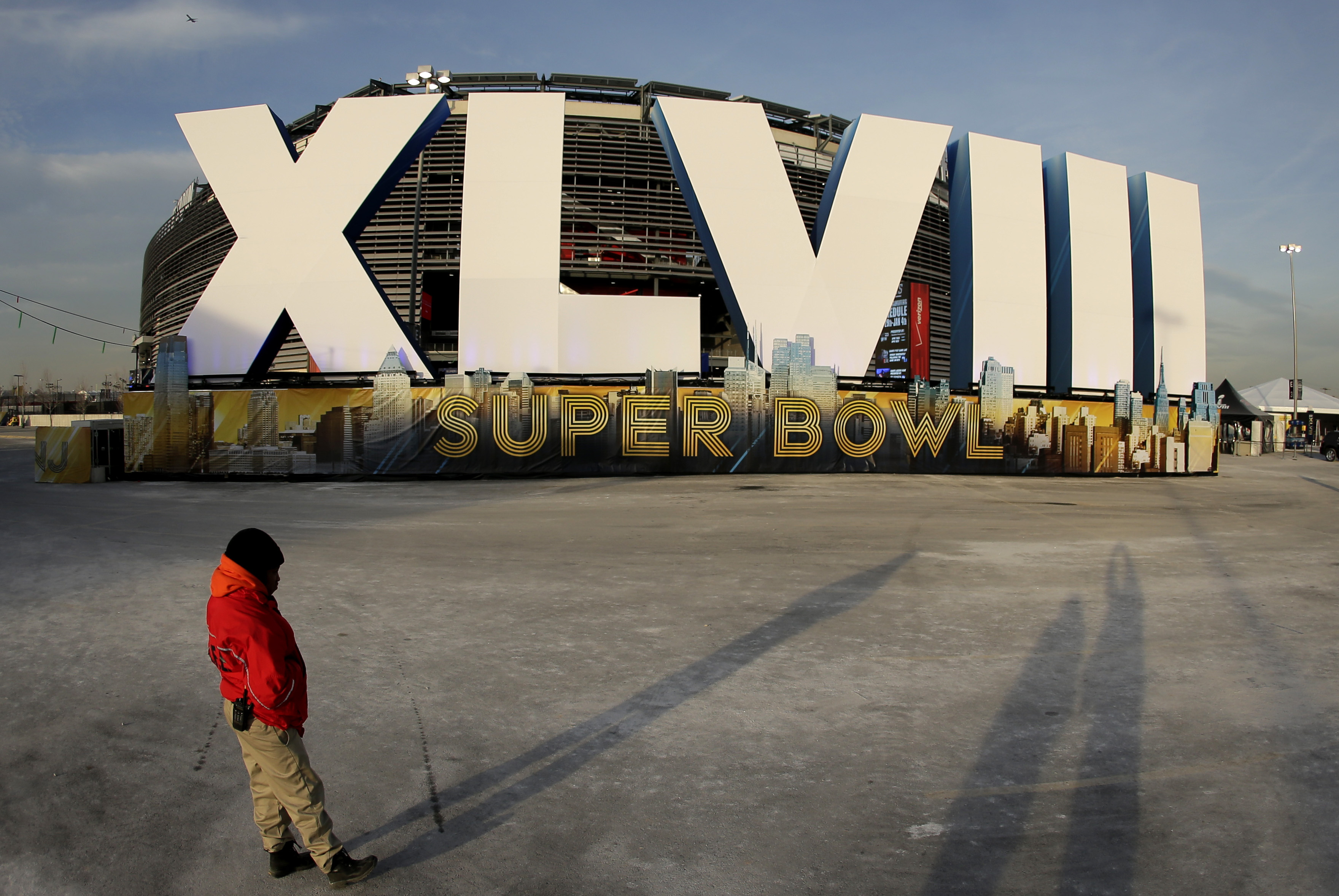 A security guard stands by a  sign for NFL football's Super Bowl XLVIII stands in front of MetLife Stadium Sat. Feb. 1, 2014, in East Ruthoford, N.J.  The stadium will be the site of Sunday's championship game between the Denver Broncos and the Seattle Seahawks. (AP Photo/Charlie Riedel)