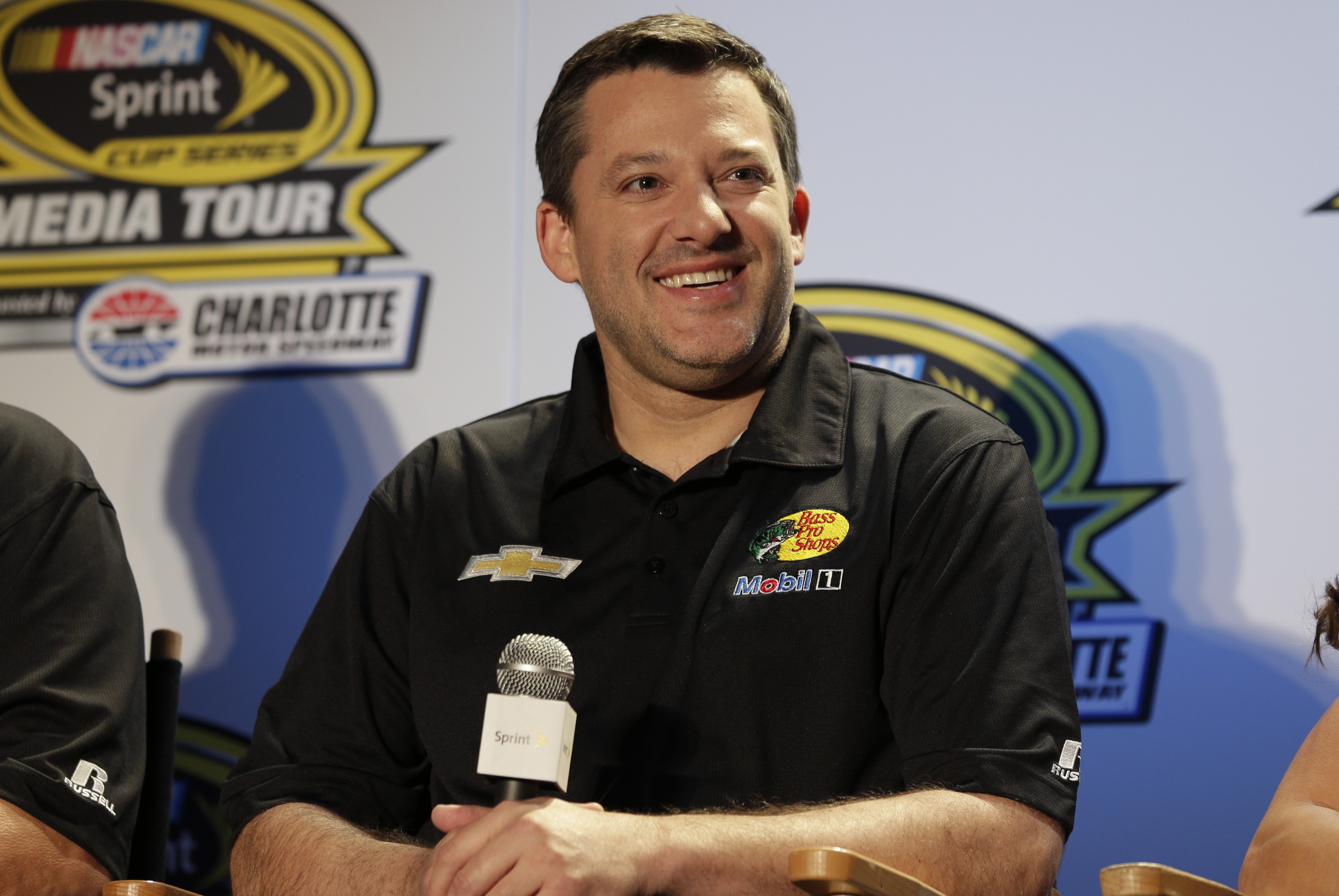 Tony Stewart smiles during news conference at the NASCAR Sprint Cup auto racing Media Tour in Charlotte, N.C., Monday, Jan. 27, 2014. (AP Photo/Chuck Burton)