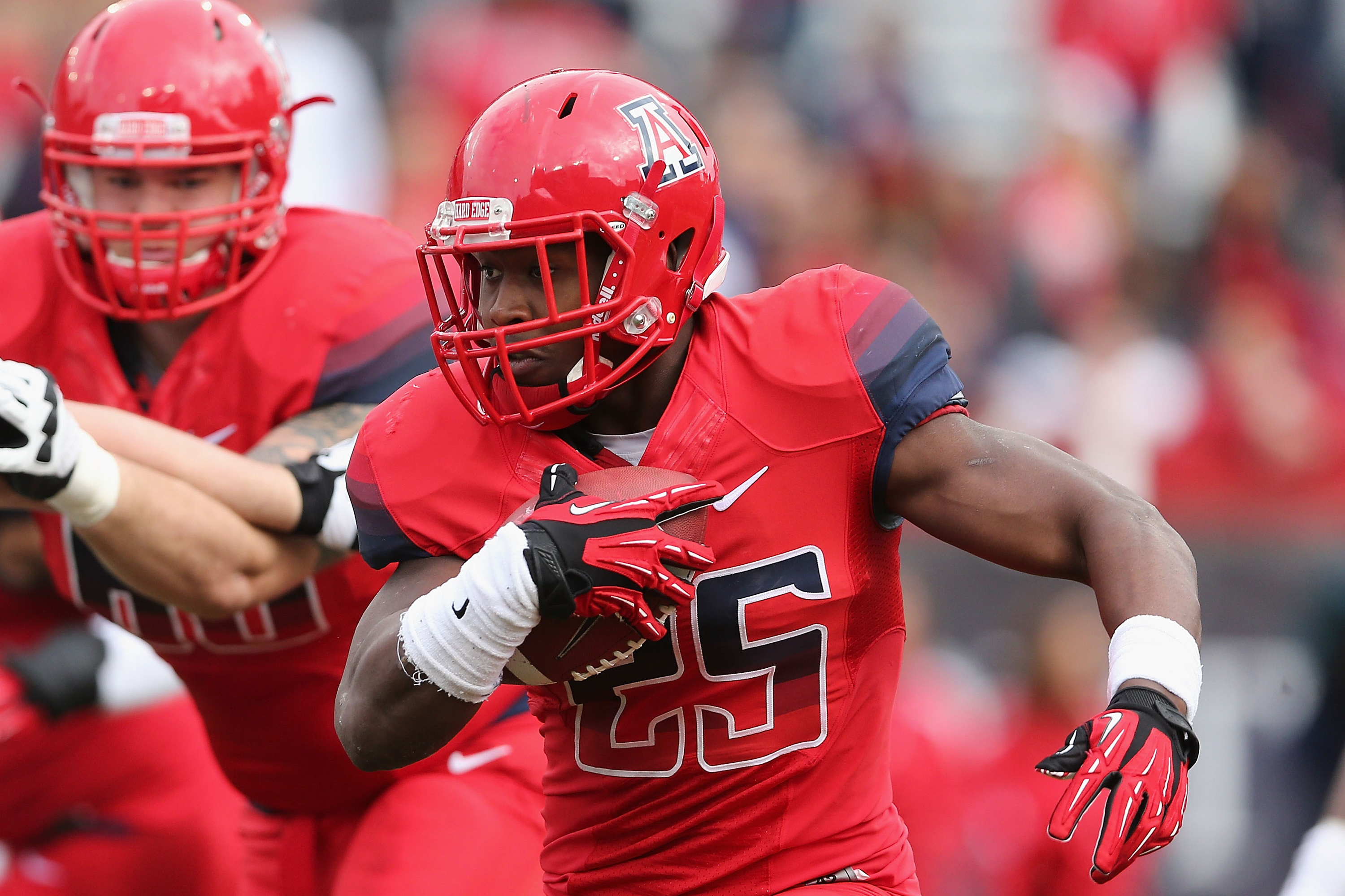 TUCSON, AZ - NOVEMBER 23:  Running back Ka'Deem Carey #25 of the Arizona Wildcats rushes the football against the Oregon Ducks during the college football game at Arizona Stadium on November 23, 2013 in Tucson, Arizona.  (Photo by Christian Petersen/Getty Images)