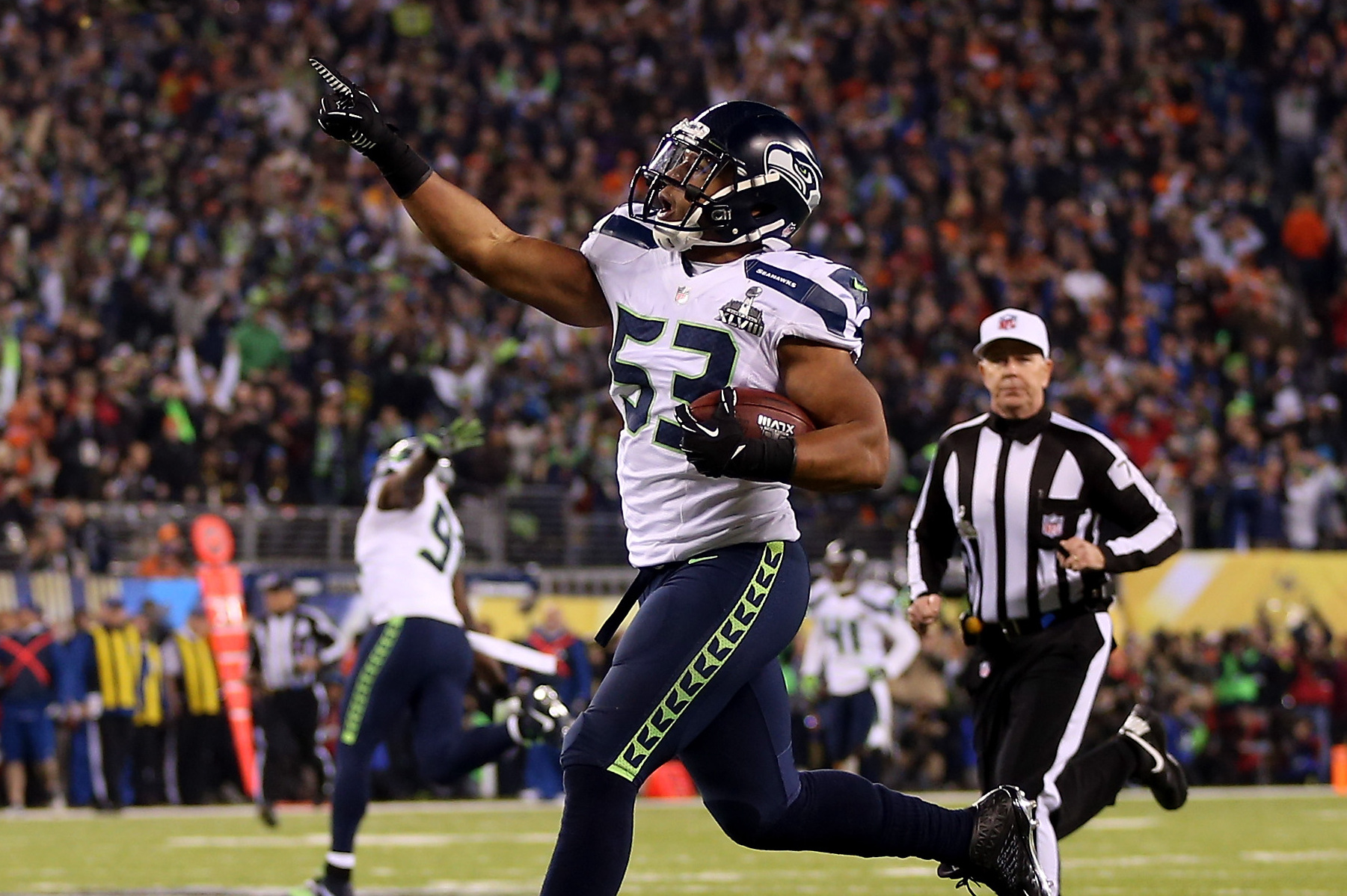 EAST RUTHERFORD, NJ - FEBRUARY 02:  Outside linebacker Malcolm Smith #53 of the Seattle Seahawks runs 69-yards for a touchdown after intercepting a pass intended for running back Knowshon Moreno #27 of the Denver Broncos in the second quarter during Super Bowl XLVIII at MetLife Stadium on February 2, 2014 in East Rutherford, New Jersey.  (Photo by Jeff Gross/Getty Images)