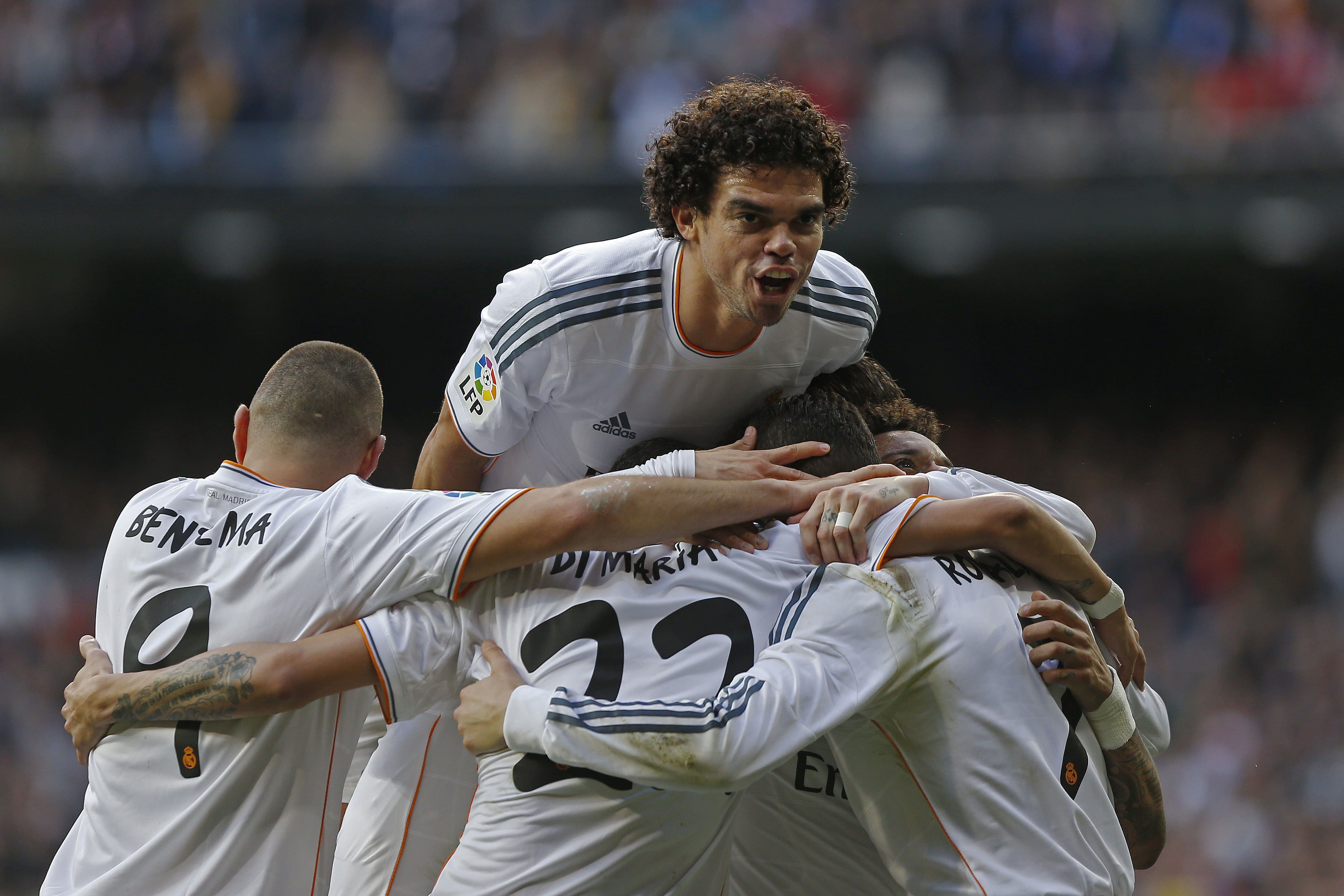 Real Madrid's Cristiano Ronaldo from Portugal, right, celebrates his goal with Pepe from Portugal, top, and team mates during a Spanish La Liga soccer match between Real Madrid and Granada at the Santiago Bernabeu stadium in Madrid, Spain, Saturday, Jan. 25, 2014. (AP Photo/Andres Kudacki)