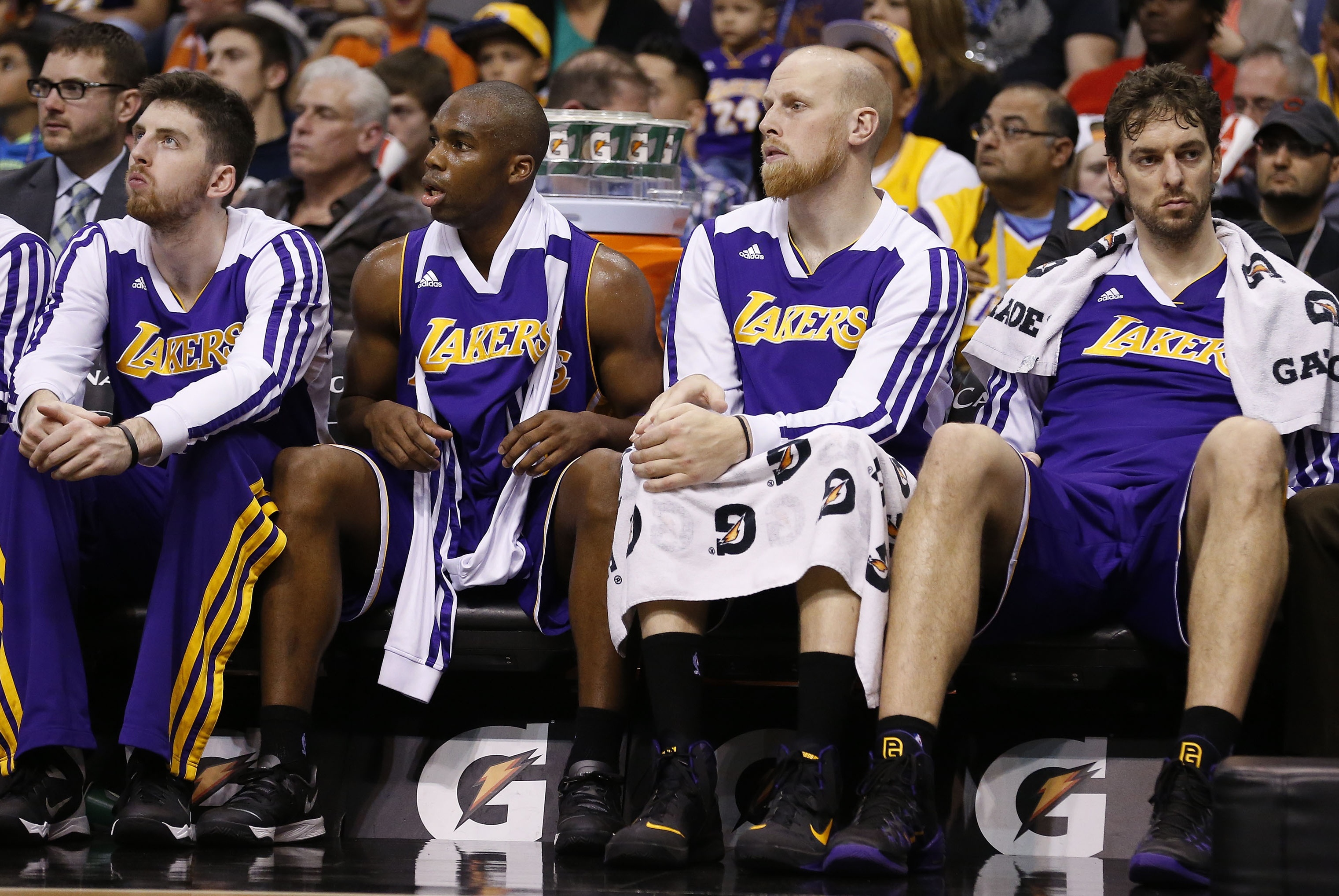 From left, Los Angeles Lakers' Ryan Kelly, Jodie Meeks, Chris Kaman and Pau Gasol all sit on the bench during the second half of an NBA basketball game Monday, Dec. 23, 2013, in Phoenix. The Suns defeated the Lakers 117-90. (AP Photo/Ross D. Franklin)