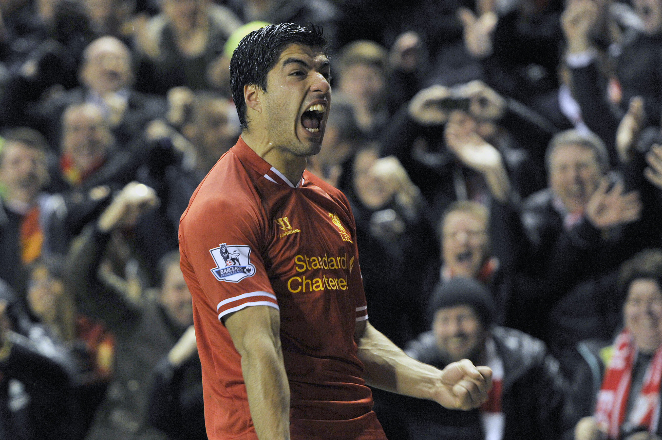 Liverpool's Luis Suarez celebrates after he scores the fourth goal of the game for his side during their English Premier League soccer match against Everton at Anfield in Liverpool, England, Tuesday Jan. 28, 2014. (AP Photo/Clint Hughes)