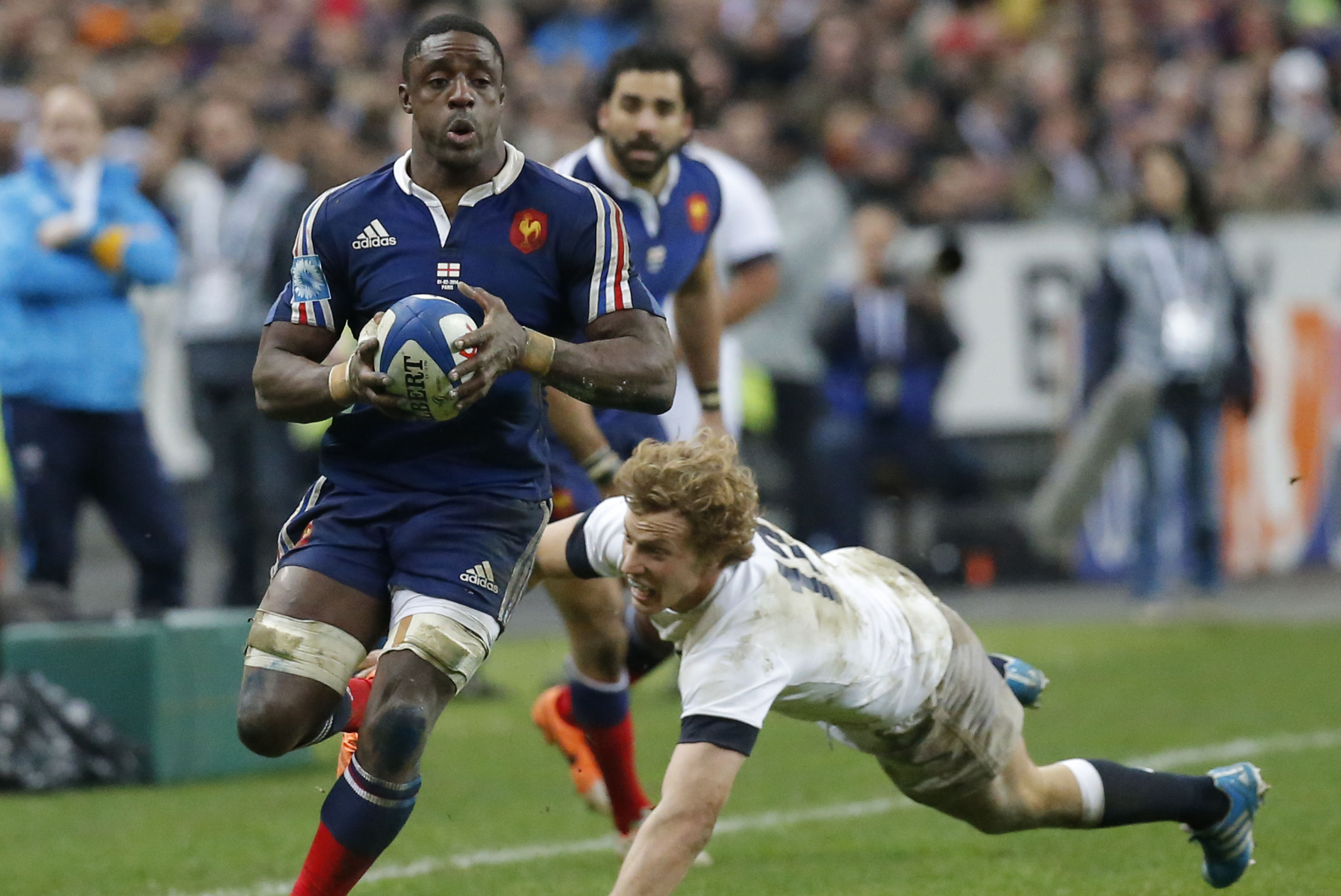 France's Yannick Nyanga, left, is tackled by England's Luther Burrell, right,  during their Six Nations international rugby union match between France and England at Stade de France stadium in Saint Denis, near Paris, Saturday, Feb. 1, 2014. France won against England 26-24. (AP Photo/Michel Euler)