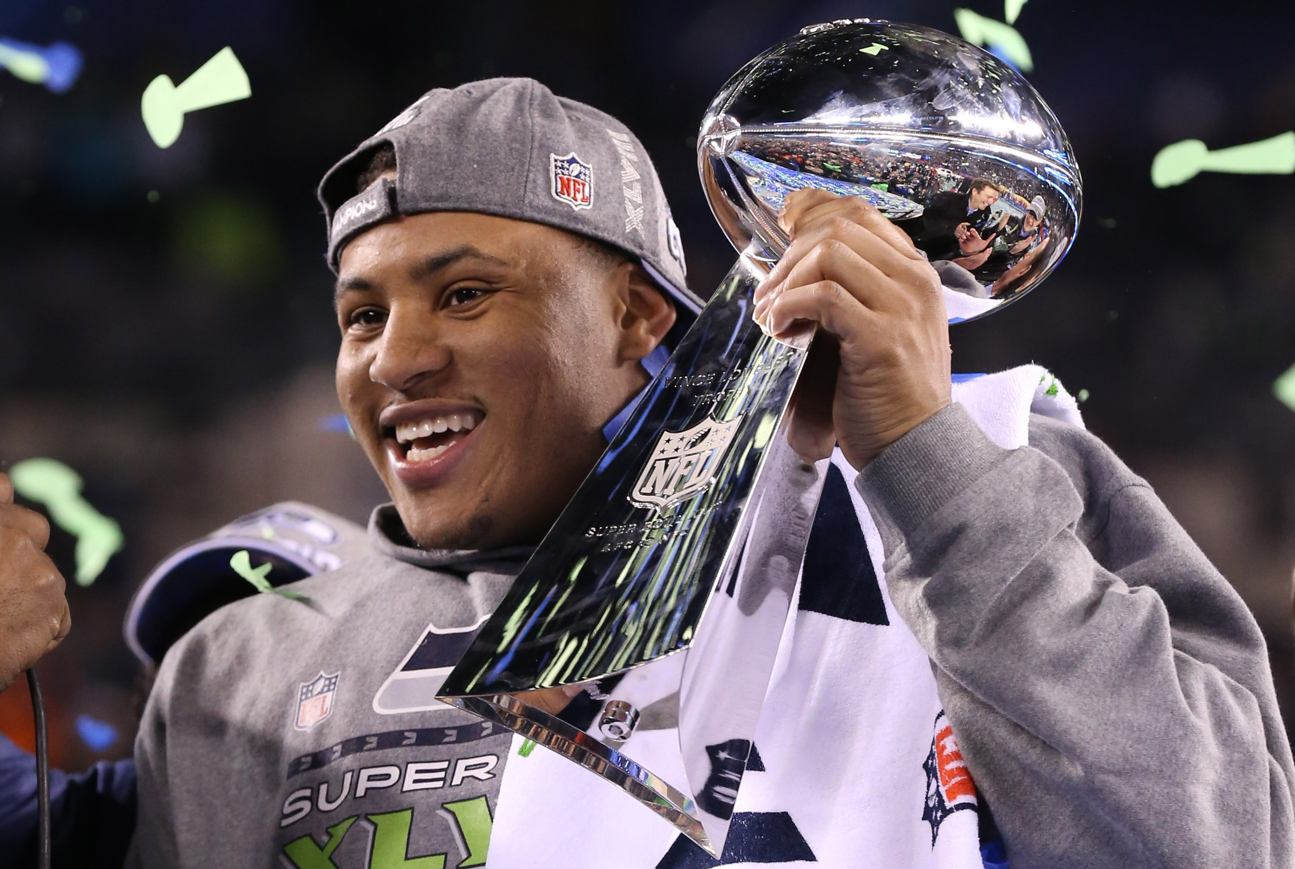 Feb 2, 2014; East Rutherford, NJ, USA; Seattle Seahawks outside linebacker Malcolm Smith (53) is awarded MVP as he hoists the Lombardi Trophy after winning Super Bowl XLVIII against the Denver Broncos at MetLife Stadium. Seattle Seahawks won 43-8. Mandatory Credit: Matthew Emmons-USA TODAY Sports