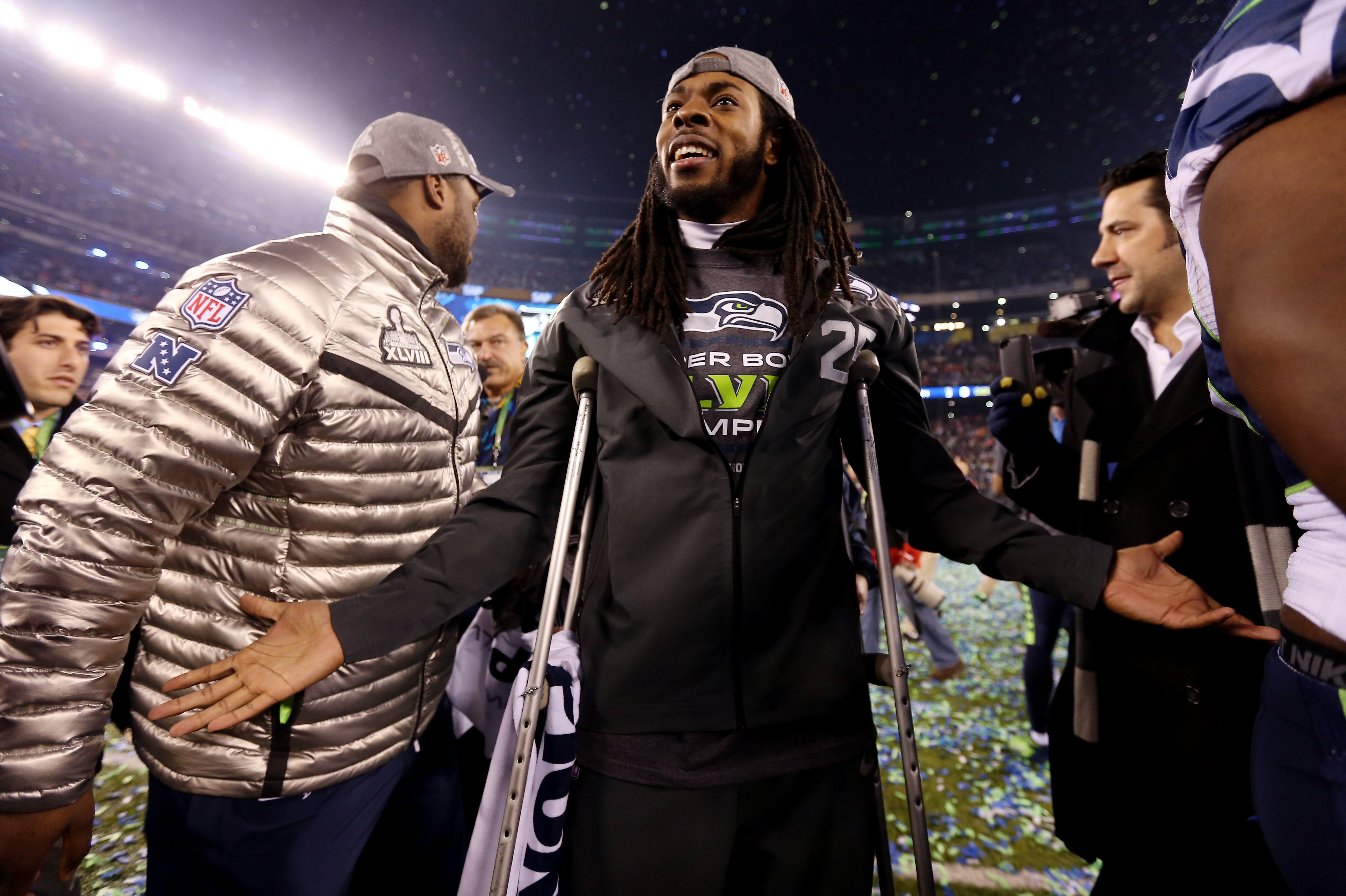 EAST RUTHERFORD, NJ - FEBRUARY 02:  Cornerback Richard Sherman #25 of the Seattle Seahawks uses crutches as he walks across the field in celebration of their 43-8 victory over the Denver Broncos during Super Bowl XLVIII at MetLife Stadium on February 2, 2014 in East Rutherford, New Jersey.  (Photo by Jeff Gross/Getty Images)