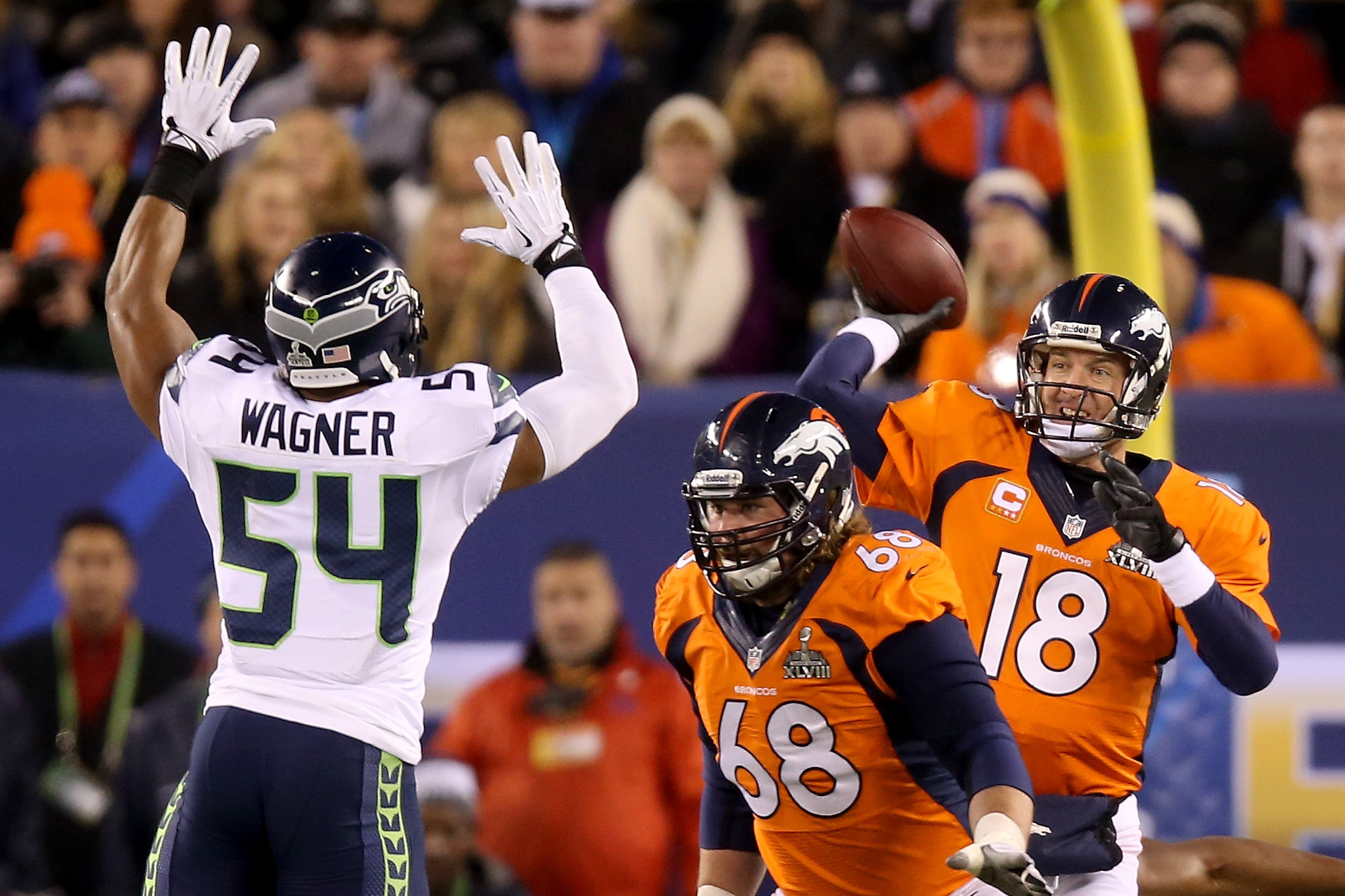 EAST RUTHERFORD, NJ - FEBRUARY 02:  Quarterback Peyton Manning #18 of the Denver Broncos throws an interception caught by strong safety Kam Chancellor #31 and intended for tight end Julius Thomas #80 of the Denver Broncos in the first quarter during Super Bowl XLVIII at MetLife Stadium on February 2, 2014 in East Rutherford, New Jersey.  (Photo by Jeff Gross/Getty Images)