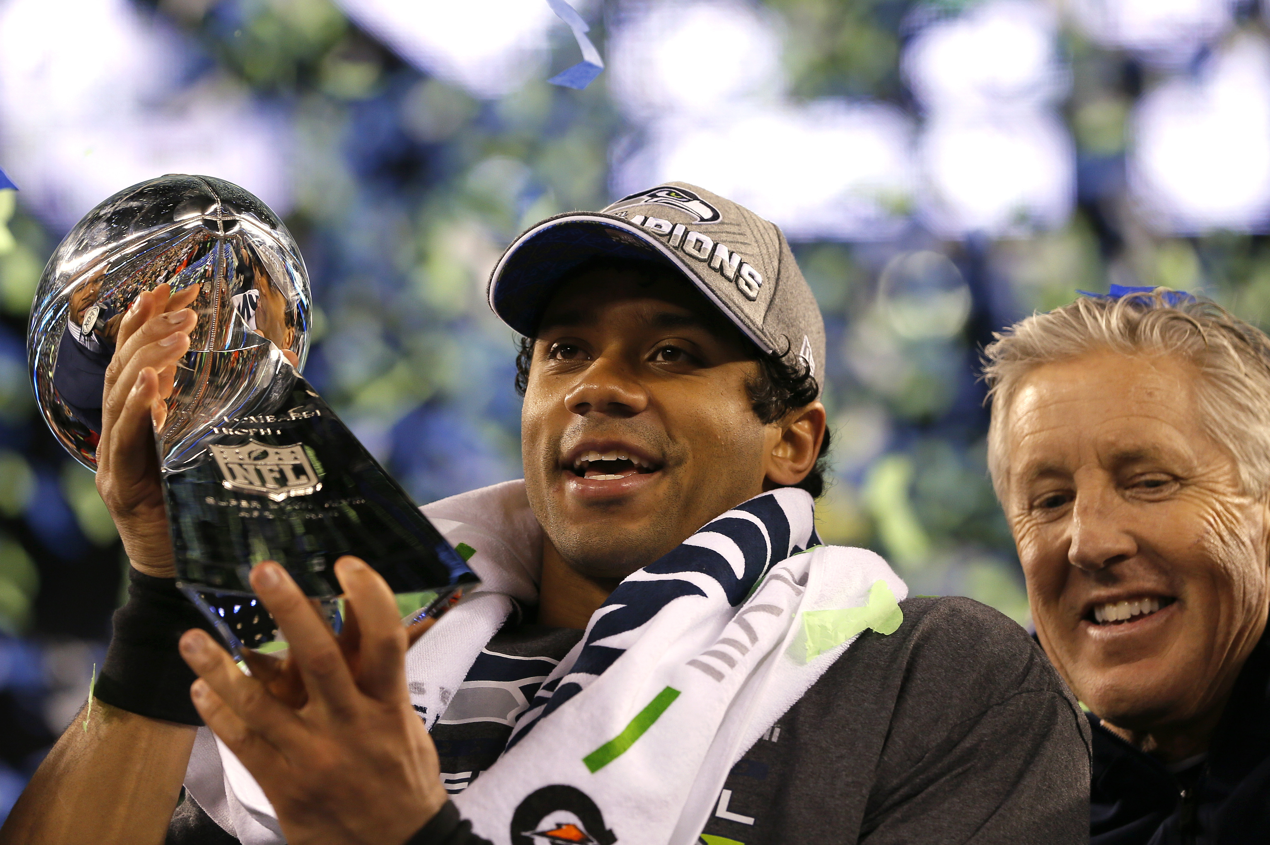 EAST RUTHERFORD, NJ - FEBRUARY 02:  Quarterback Russell Wilson #3 of the Seattle Seahawks celebrates with the Vince Lombardi Trophy alongside head coach Pete Carroll after their 43-8 victory over the Denver Broncos during Super Bowl XLVIII at MetLife Stadium on February 2, 2014 in East Rutherford, New Jersey.  (Photo by Kevin C. Cox/Getty Images)