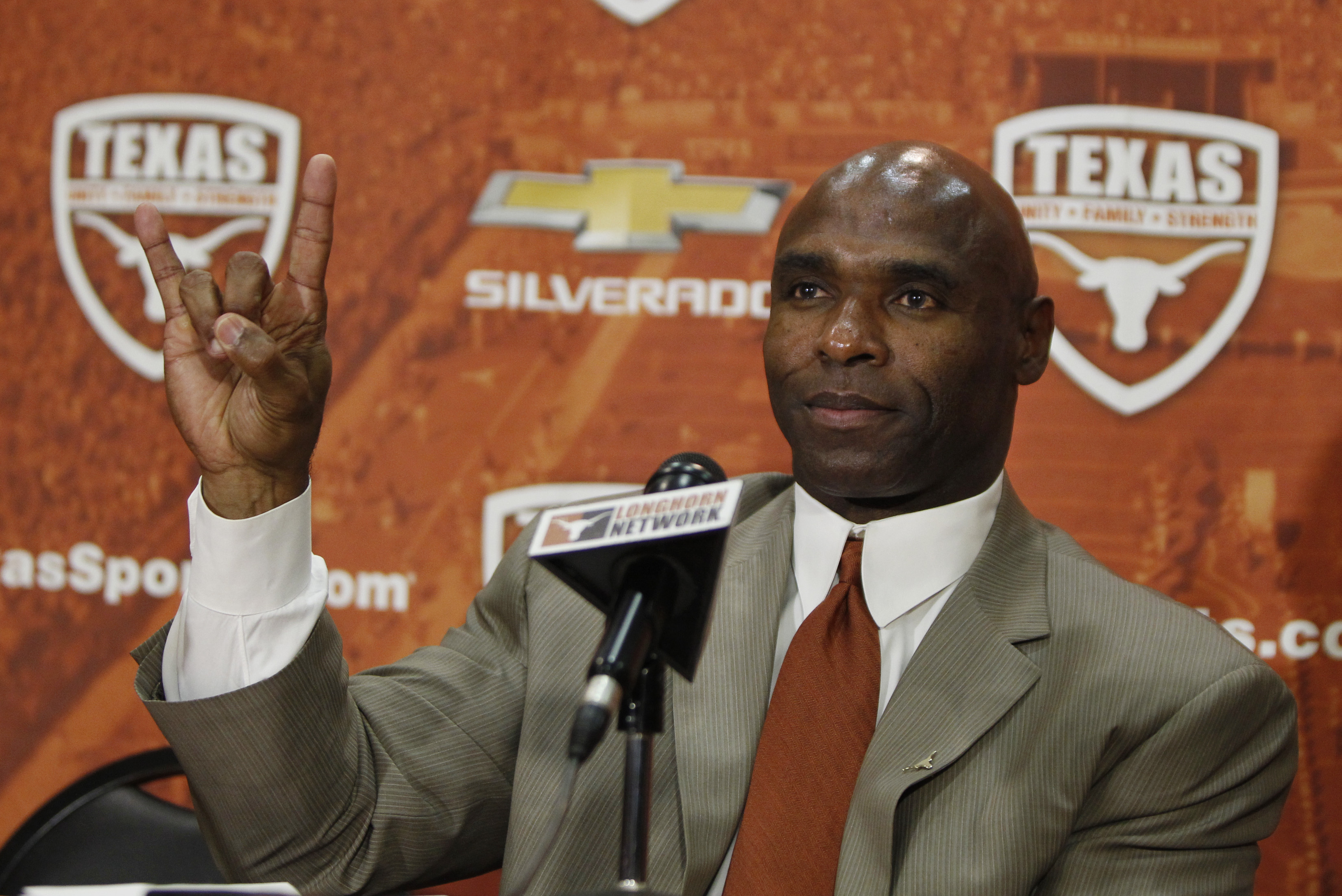 AUSTIN, TX - JANUARY 6: The University of Texas Longhorns new head football coach Charlie Strong from Louisville flashes the 'Hook 'Em Horns' sign after being introduced during a press conference January 6, 2014 at Darrell K. Royal-Texas Memorial Stadium in Austin, Texas.  (Photo by Erich Schlegel/Getty Images)