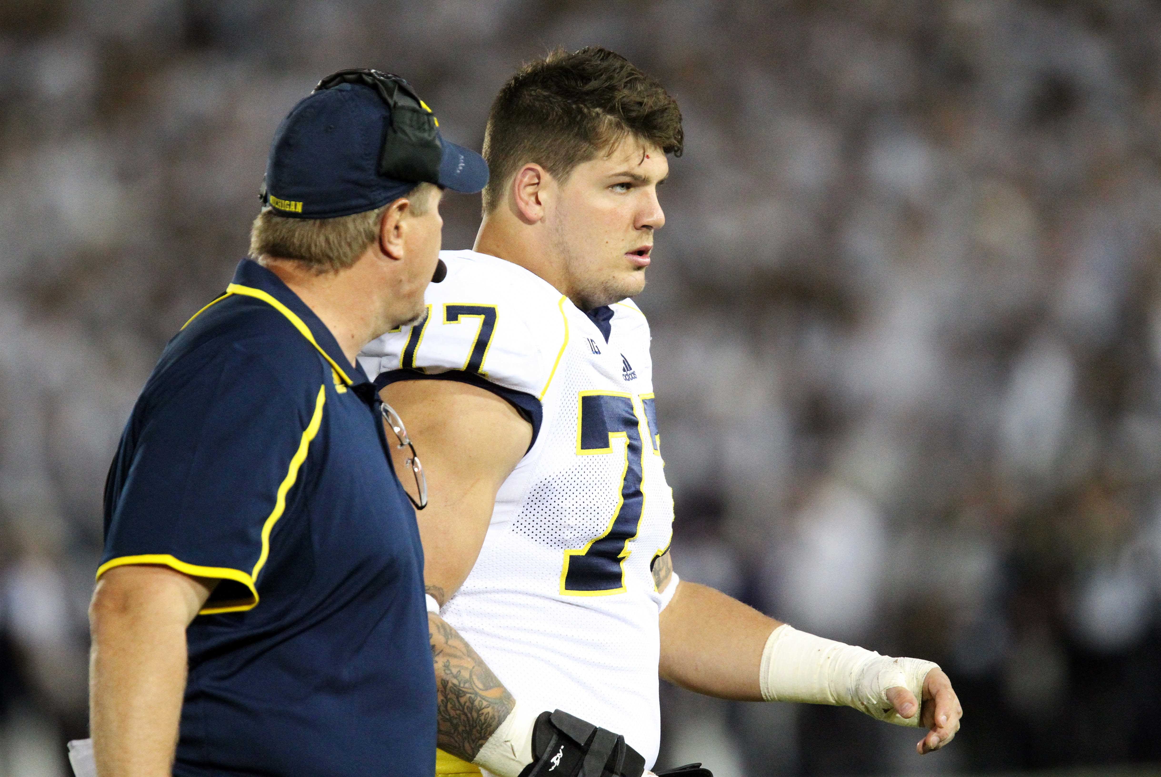 Oct 12, 2013; University Park, PA, USA; Michigan Wolverines offensive linesmen Taylor Lewan (77) walks off the field during the fourth quarter against the Penn State Nittany Lions at Beaver Stadium. Penn State defeated Michigan 43-40 in overtime. Mandatory Credit: Matthew O'Haren-USA TODAY Sports